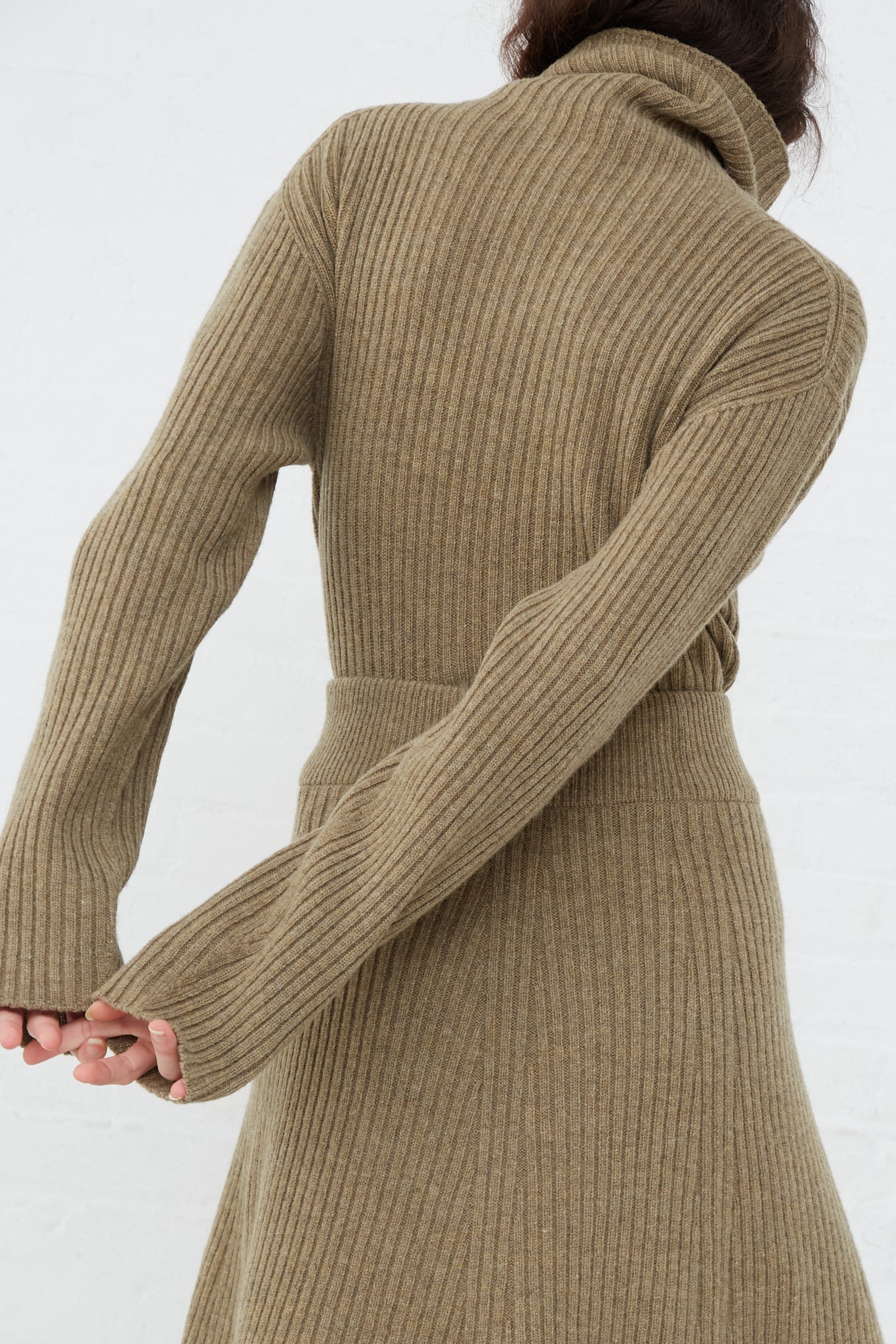 The back of a woman in an Ichi Antiquités Wool Rib Knit Turtleneck in Mocha.