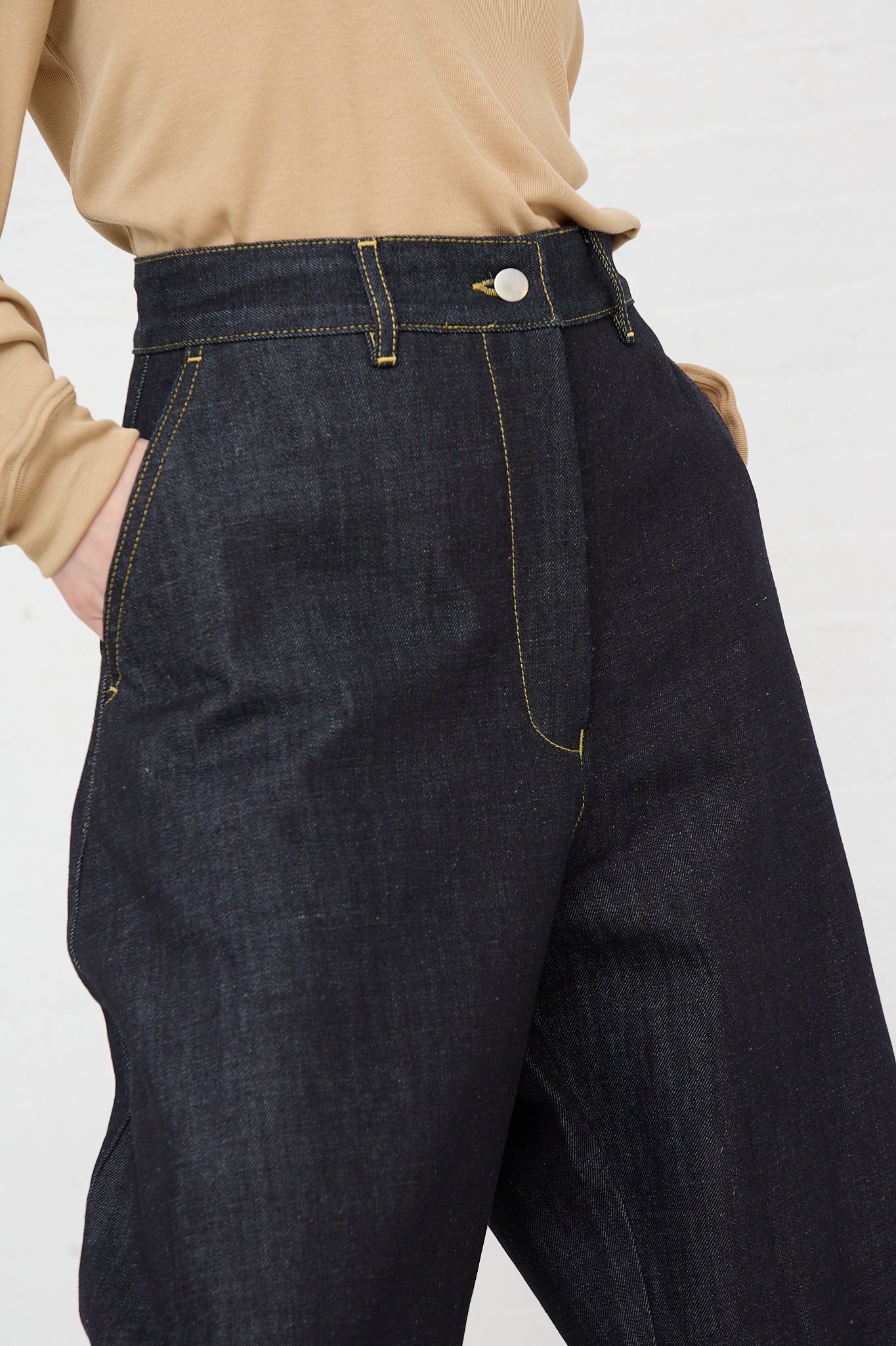The back of a woman wearing Studio Nicholson's Chalco Wide Crop Jean in Raw Indigo, made from recycled denim.