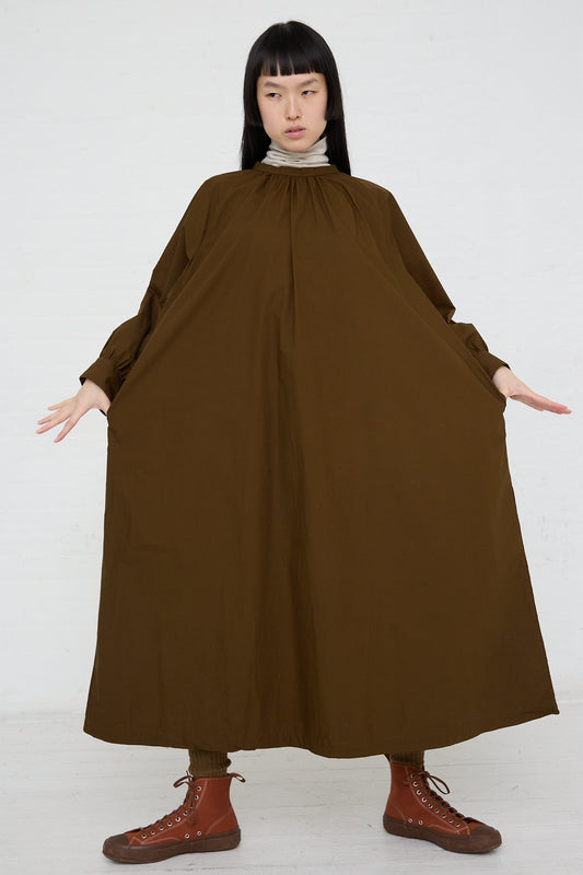 A woman wearing a Woven Cotton Dress in Seal Brown by Ichi, standing in front of a white background.
