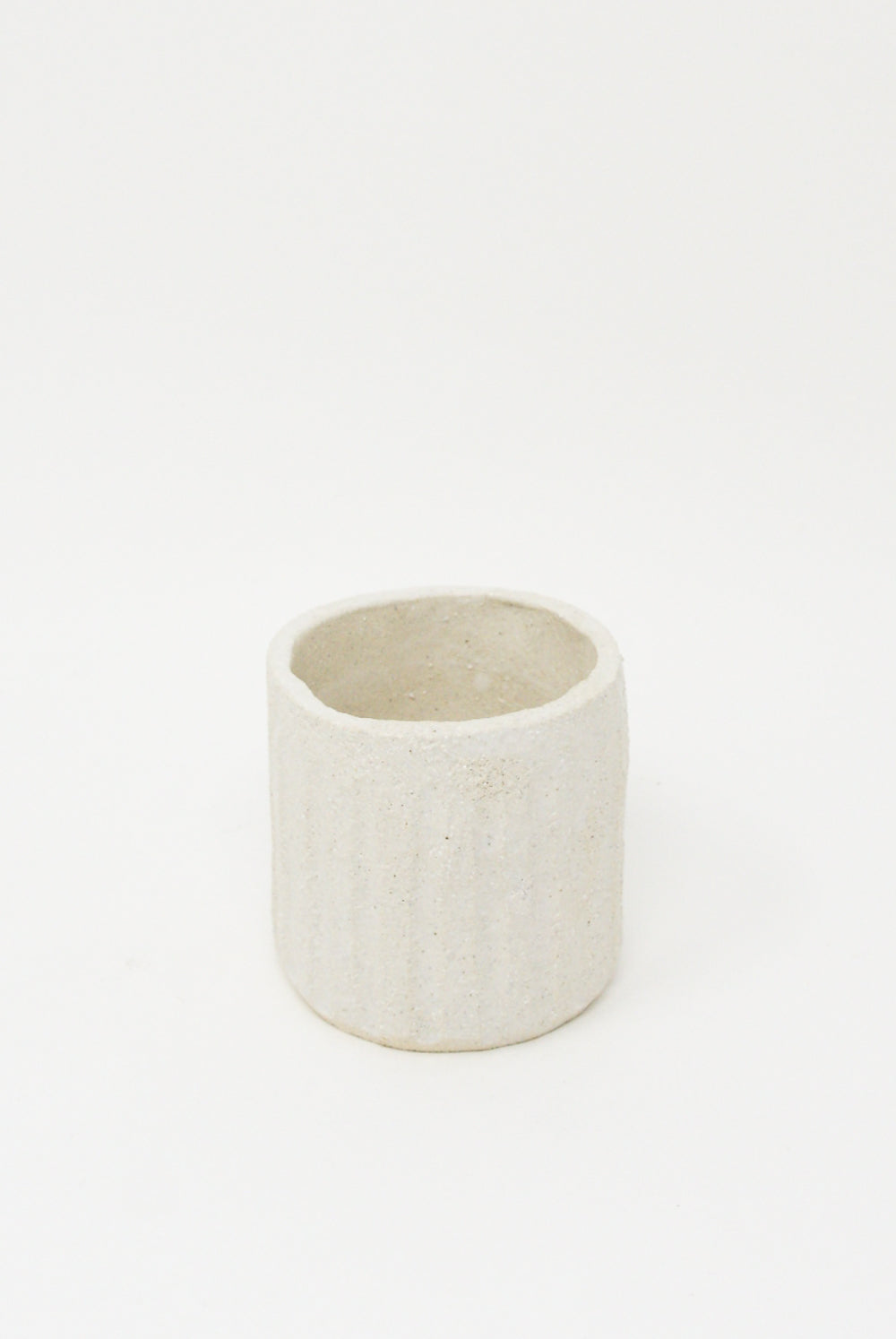 A small handmade ceramic Tea Cup in Natural by Clandestine on a white background.