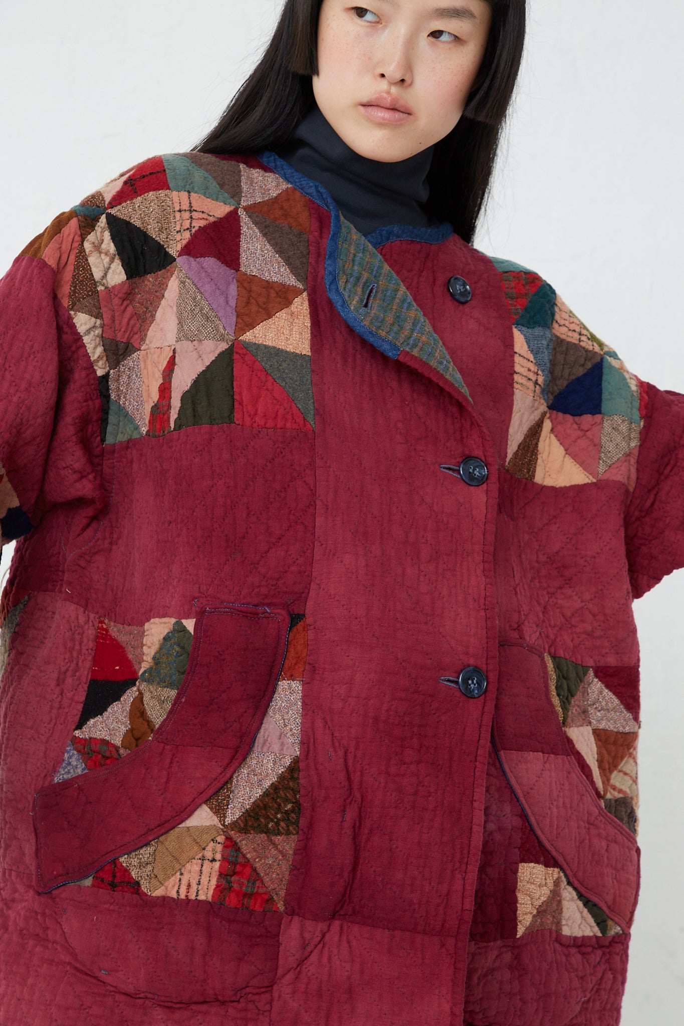 A woman wearing an oversized red As Ever Quilt Jacket in Mulberry.