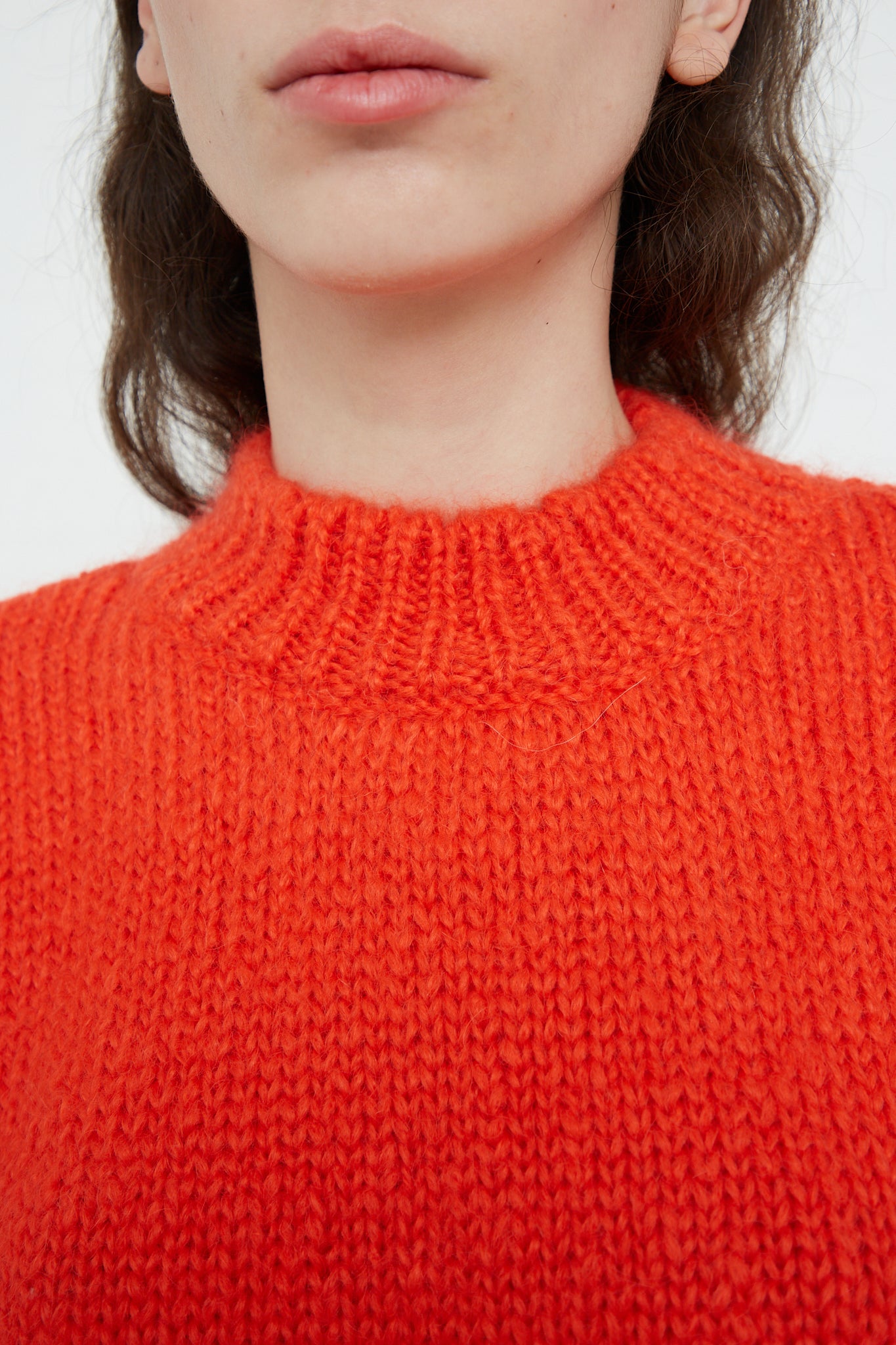 A woman wearing an oversized Cordera Mohair Sweater in Tangerine. Up close.