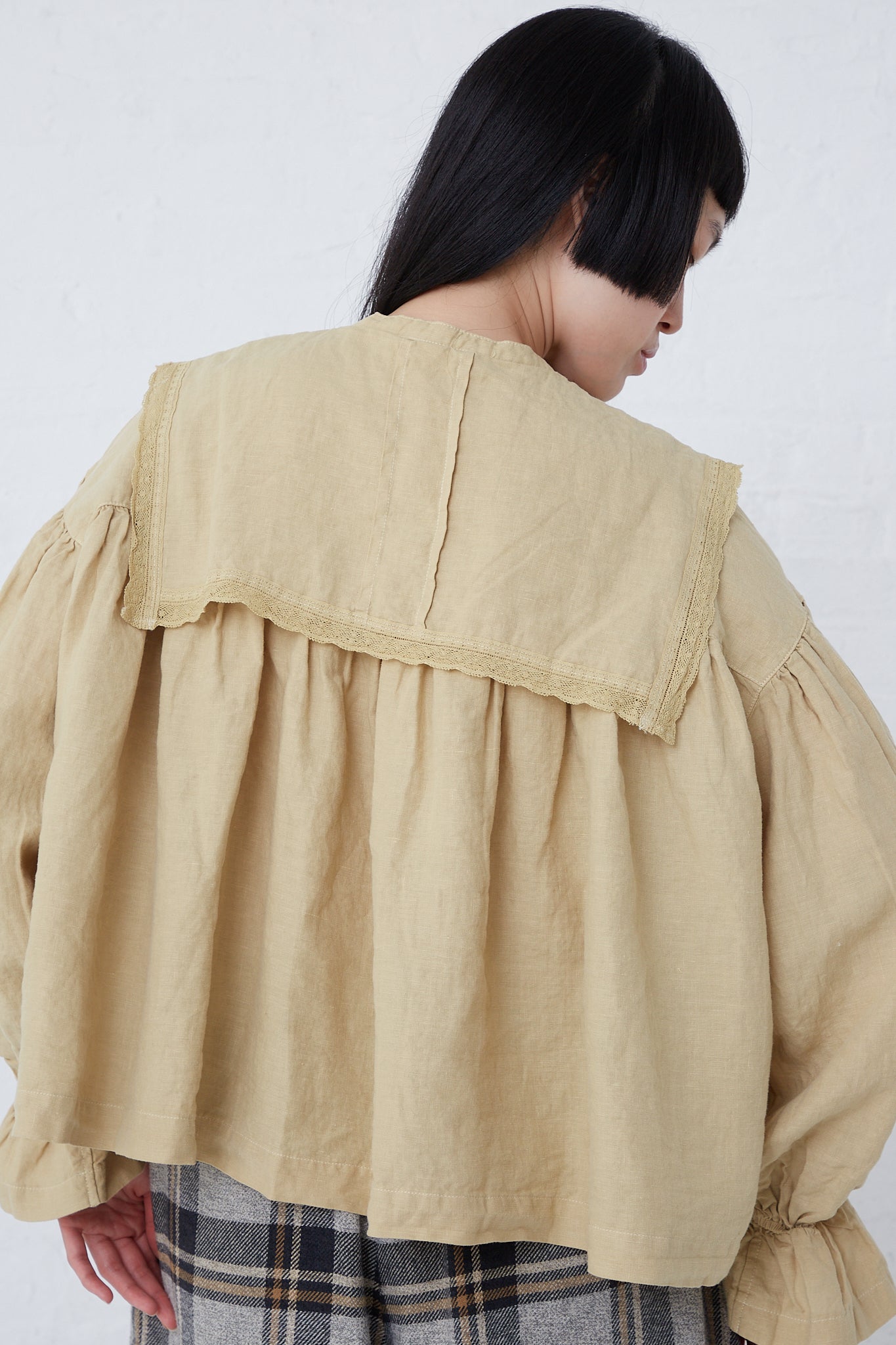 The back of a woman wearing a nest Robe Natural Dyed Linen Lace Blouse in Yellow.