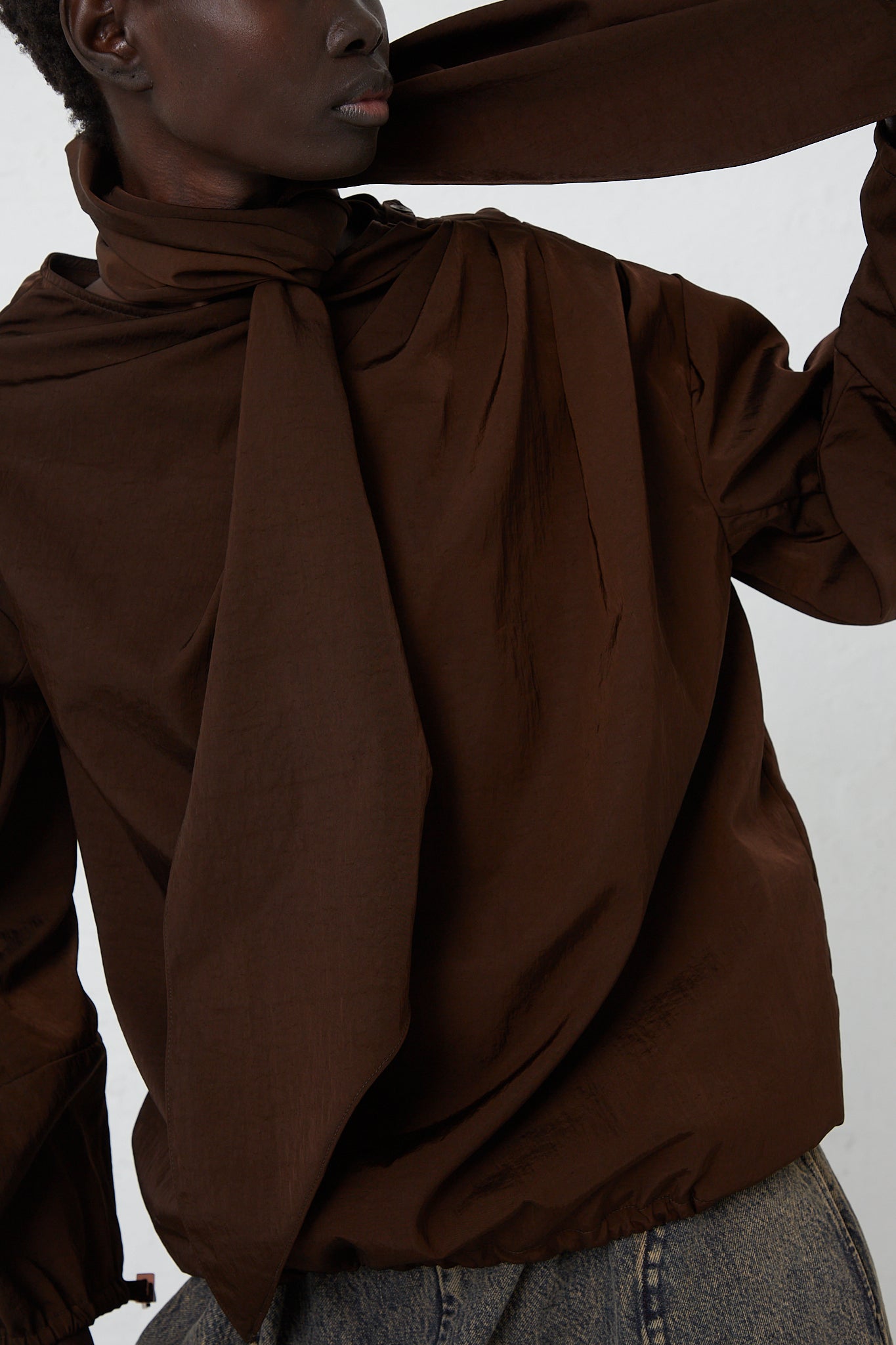 A woman is posing in a Veronique Leroy Zipped on Sleeve Rain Blouse in Choco.