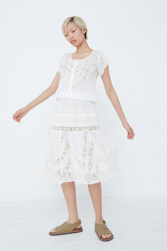 A woman wearing a white cotton Lucy Skirt in Dreamy Sand by Loretta Caponi with sandals.