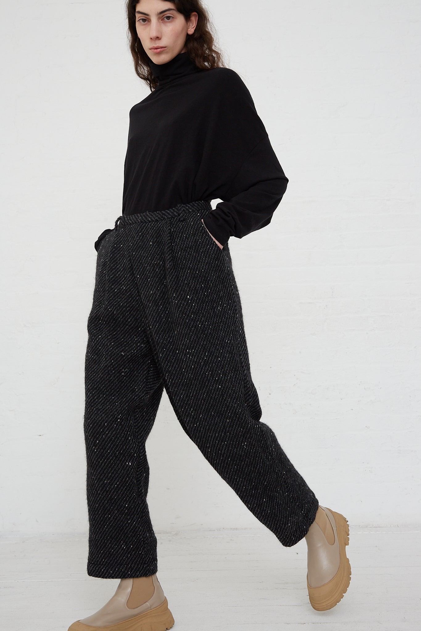 The model is wearing Ichi Antiquités Snow Nep Wool Pant in Black and a black turtleneck.