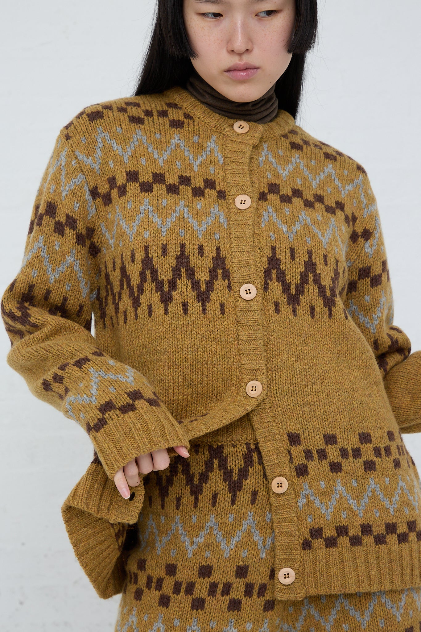 A model wearing an Ichi Wool Knit Cardigan in Camel in a multi-color design.