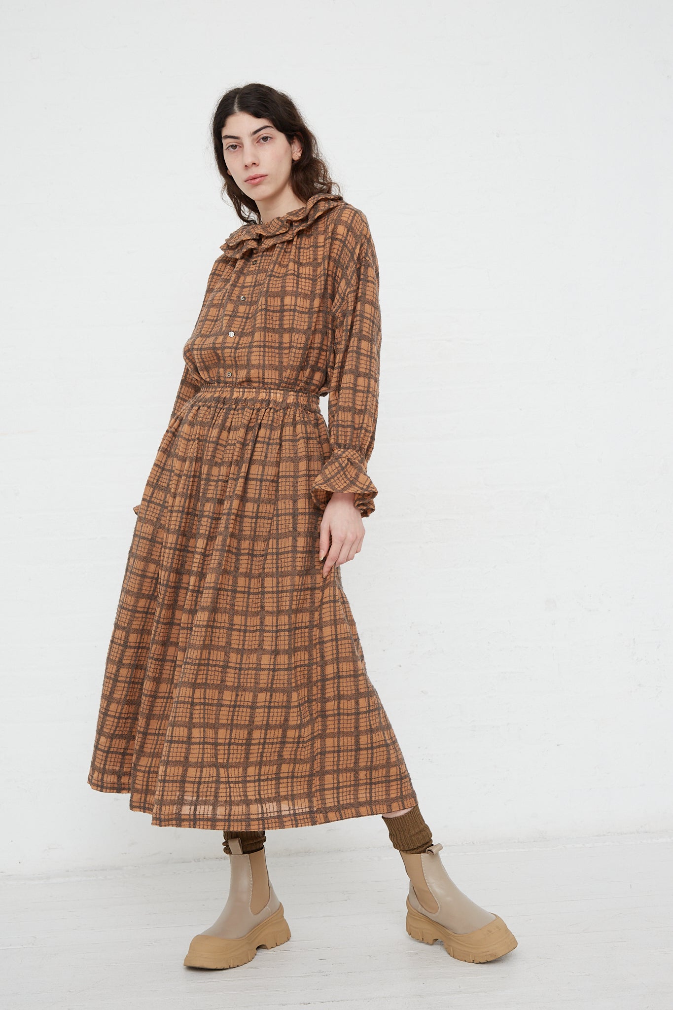 The model is wearing a Woven Wool Check Skirt in Terracotta by Ichi Antiquités with an elasticated waist.