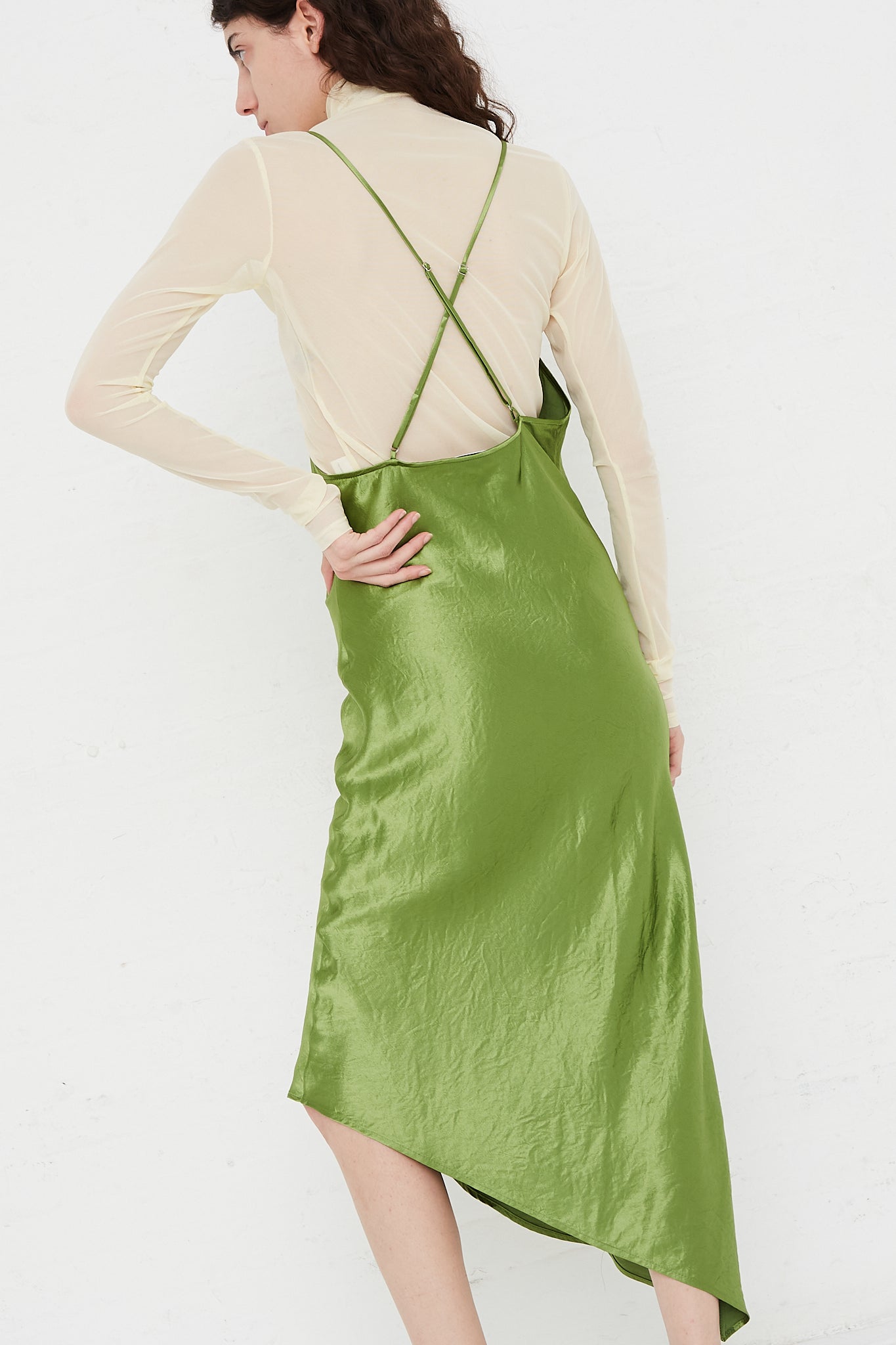 A model wearing a Vintage Washed Satin Halter Dress in Kiwi designed by Nomia brand.