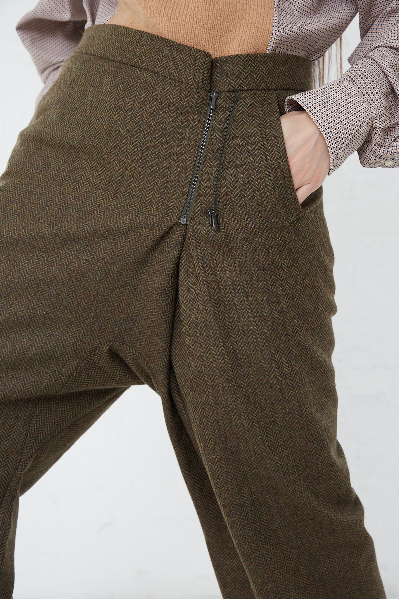 A woman wearing the Bless No. 75 Wool Long Pant in Purple Greenish Tweed and a brown sweater.