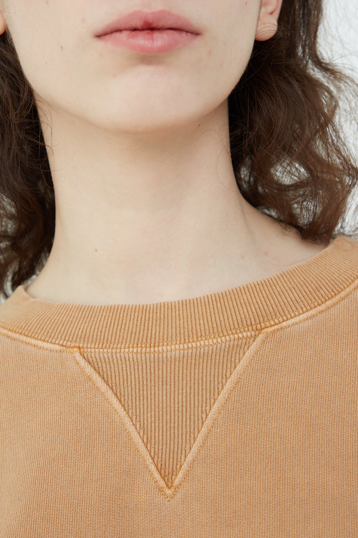A woman wearing an oversized Ichi Antiquités Pigment French Terry Cotton Pullover in Camel.