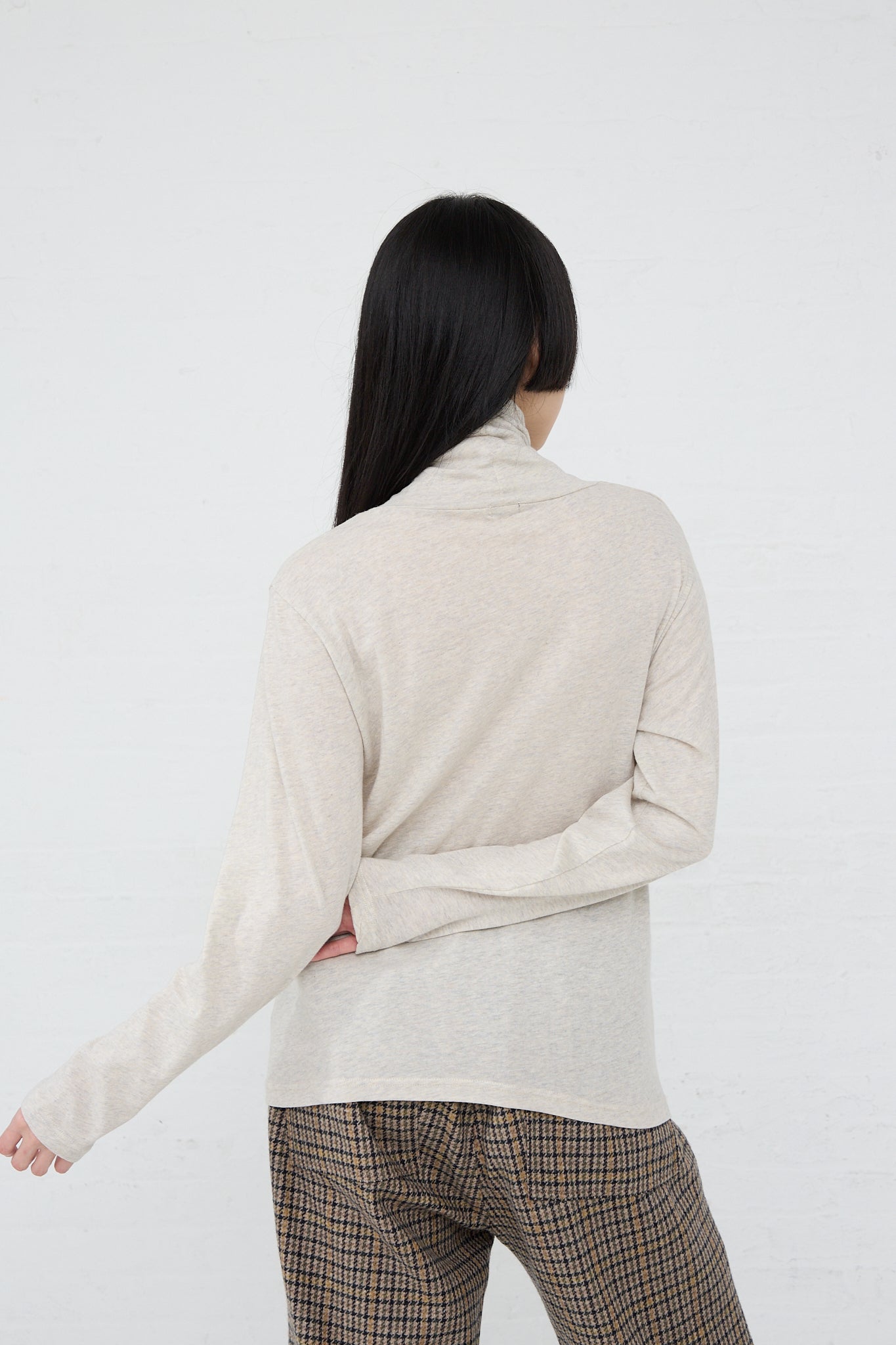 The back of a woman wearing an Ichi Cotton Knit Turtleneck in Oatmeal sweater.