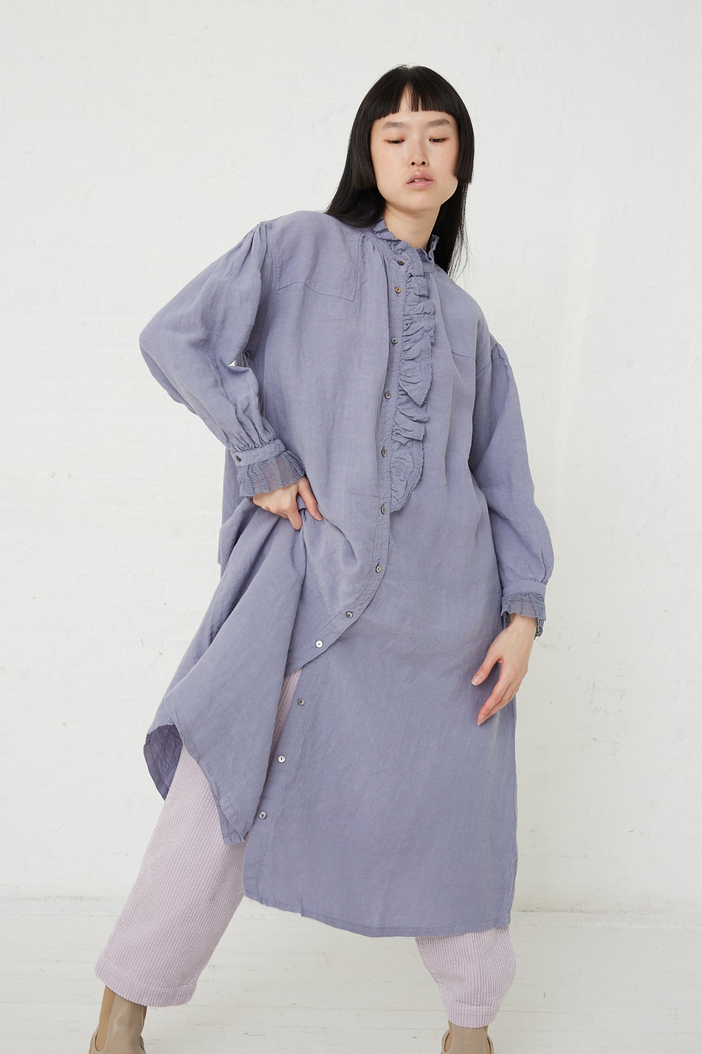 The model is wearing a nest Robe Linen Cotton Lace Omi-Zarashi Dress in Lavender, featuring a front button closure and dyed linen fabric.