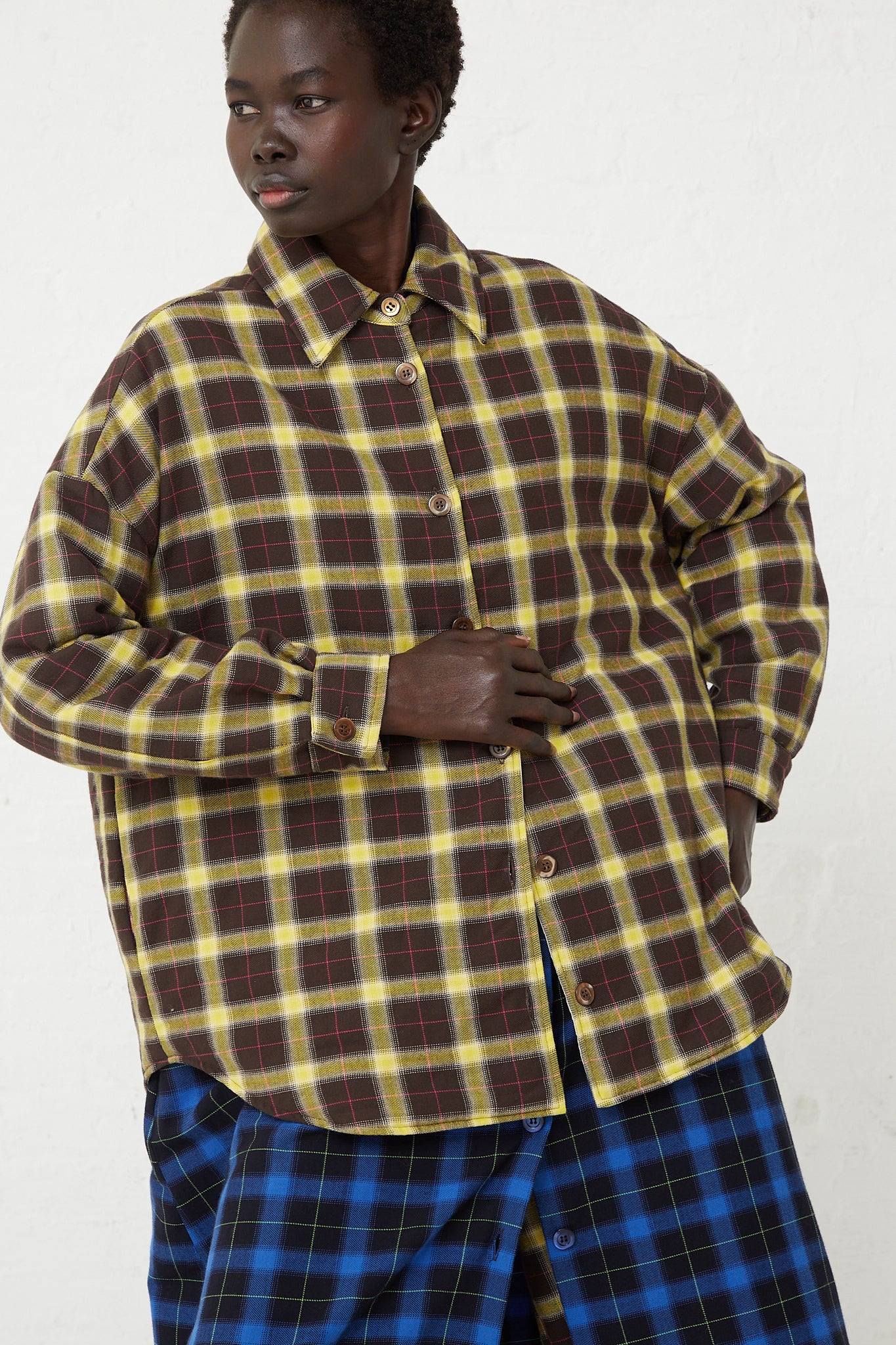 A model wearing an AVN Padding Shirt in Check Brown, Yellow and Pink, made of cotton, perfect for menswear.