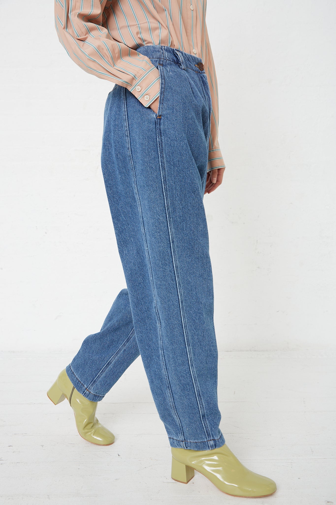 A woman wearing a pair of Rachel Comey Denim Percy Pant in Indigo, in a relaxed fit pant with green shoes.