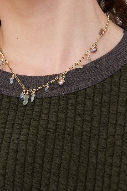 A woman wearing a green sweater and Sapphire & Keshi Pearl Necklace with pearls by Tara Turner.