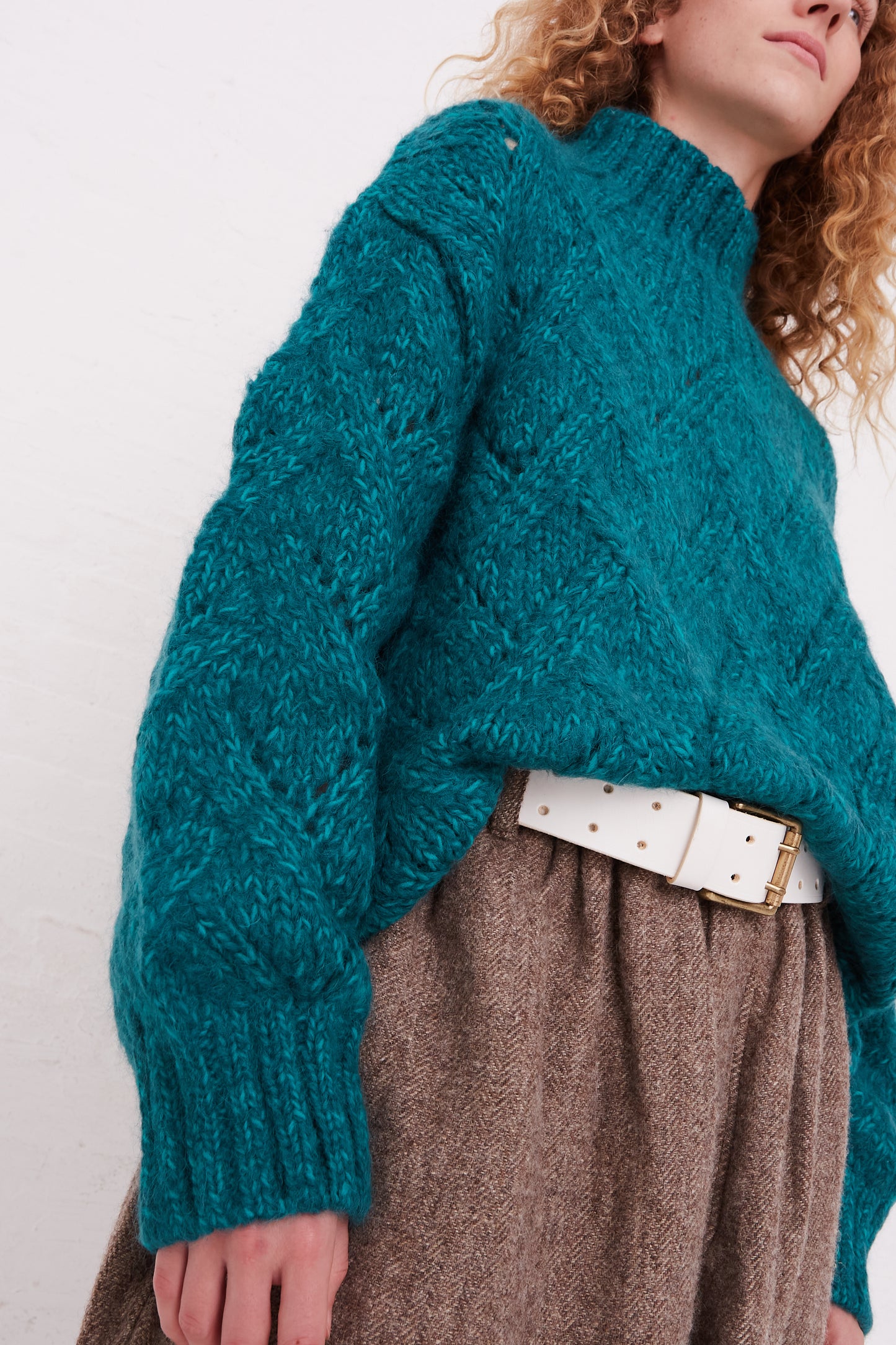 An oversized Hand-Knit Turtleneck in Green Teal by Ichi Antiquités and brown skirt.