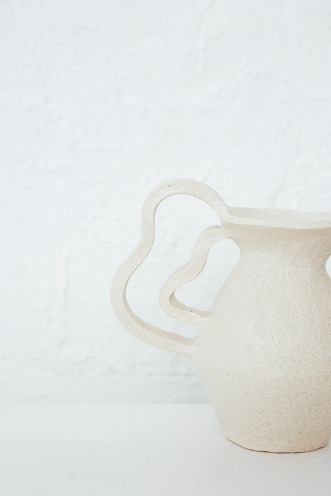 An Amphora Le Petit Doubles Vagues vase sitting on a white table. Designed by Clandestine.