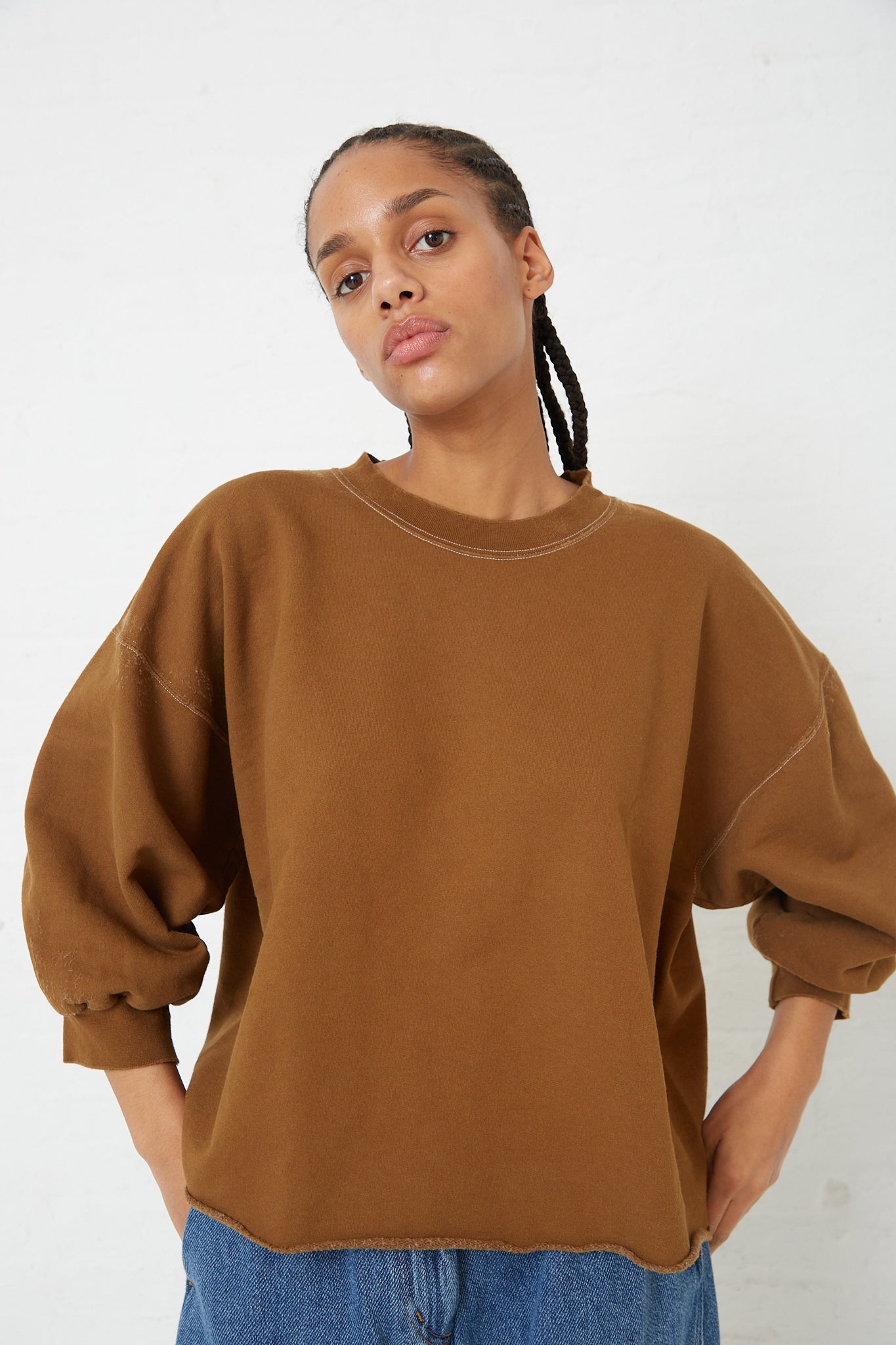 The model is wearing a Rachel Comey Fond Sweatshirt in Umber.