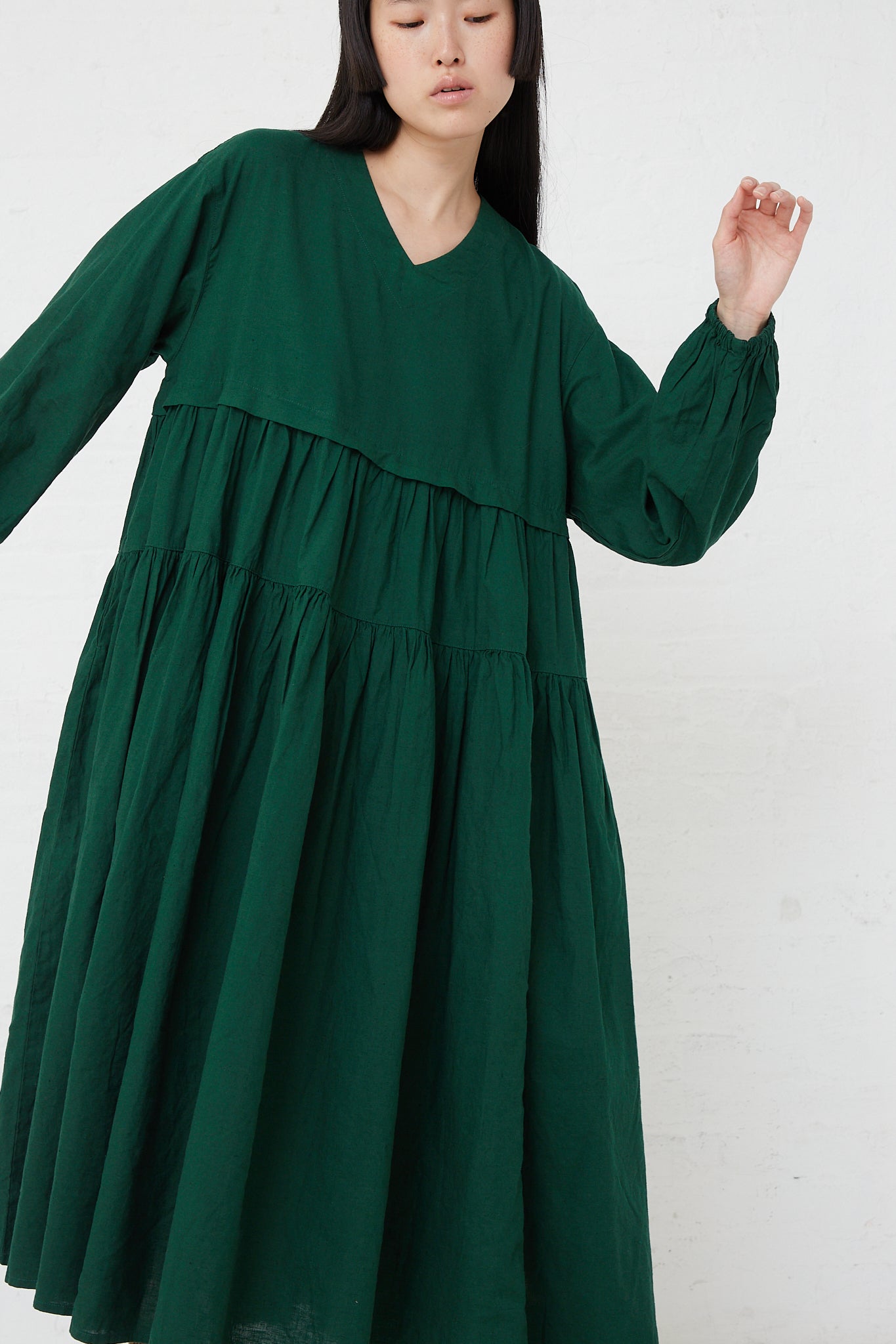 The model is wearing an UpcycleLino Linen Tiered Gather Dress in Green with ruffles made from linen by nest Robe.