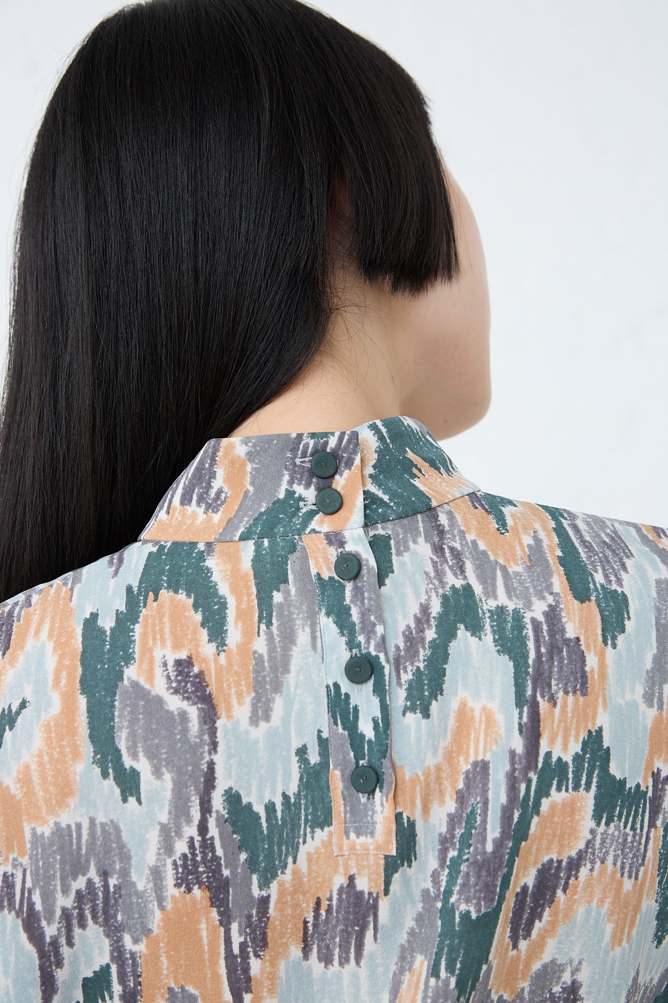 The back view of a woman wearing a Mina Perhonen Light Dance Blouse in Gray Mix. Up close and back view.