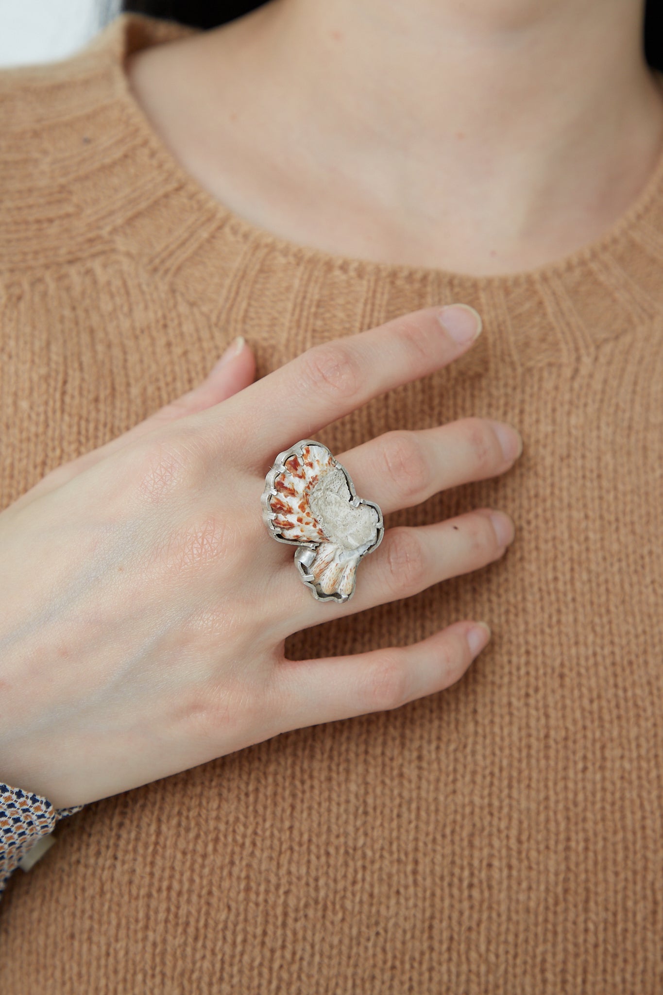 A woman wearing a brown sweater and a La Mar Sterling Silver Shell Ring 003 B.