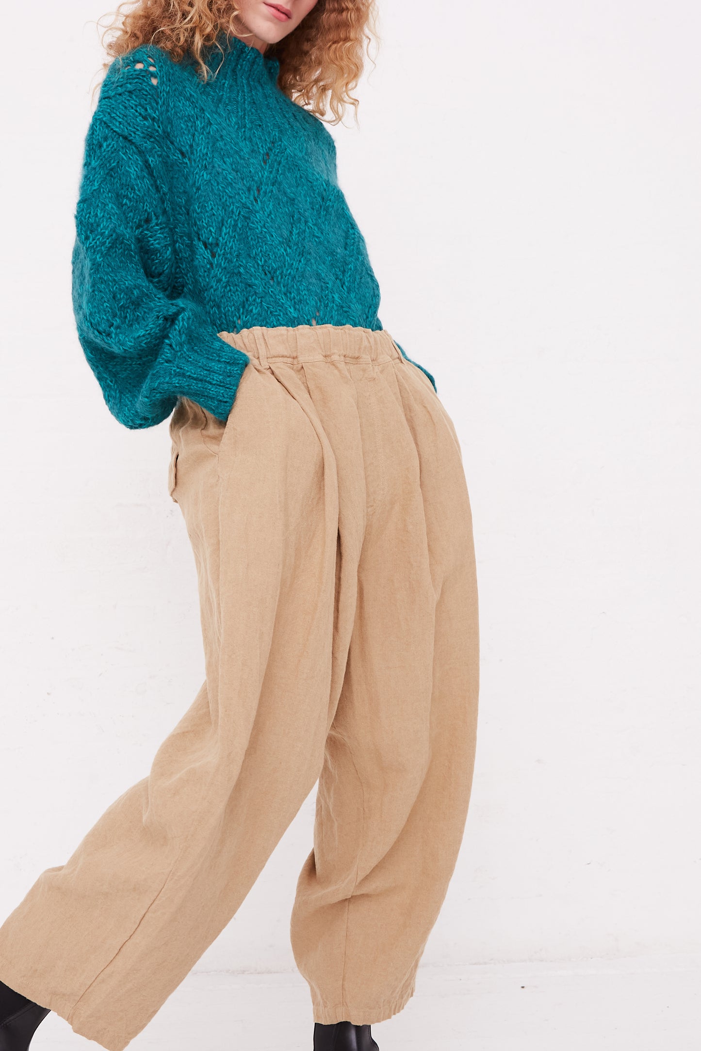 A model wearing a teal sweater and relaxed fit Ichi Antiquités Linen Canvas Pants in Beige.
