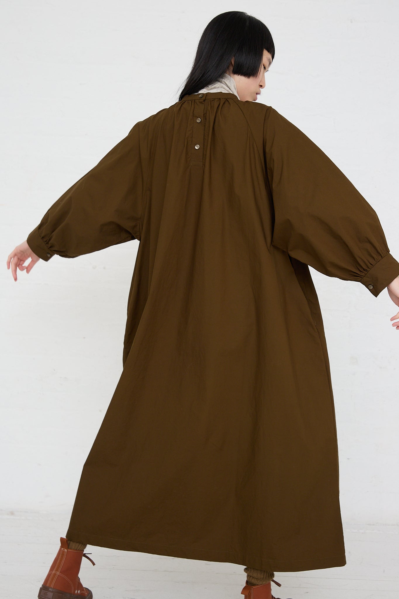 A woman wearing a Ichi Woven Cotton Dress in Seal Brown and boots. Back view.