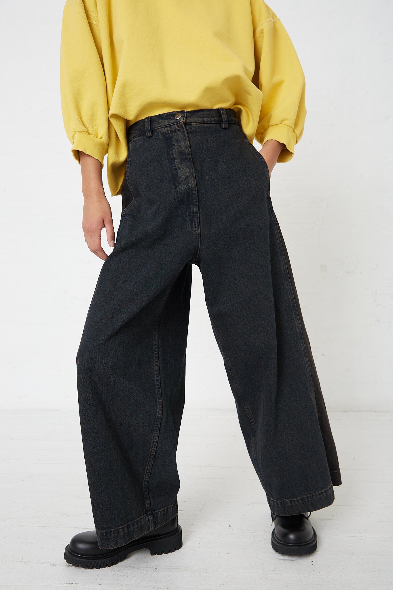 A woman wearing a yellow shirt and relaxed fit, black wide leg Rachel Comey Denim Garra Pant in Brown.