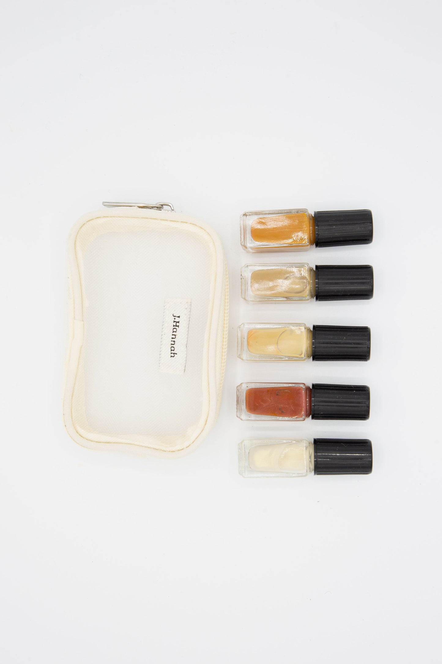 A small pouch with a Mini Polish Set in Classics by J Hannah, consisting of high quality lipsticks and lip balms.