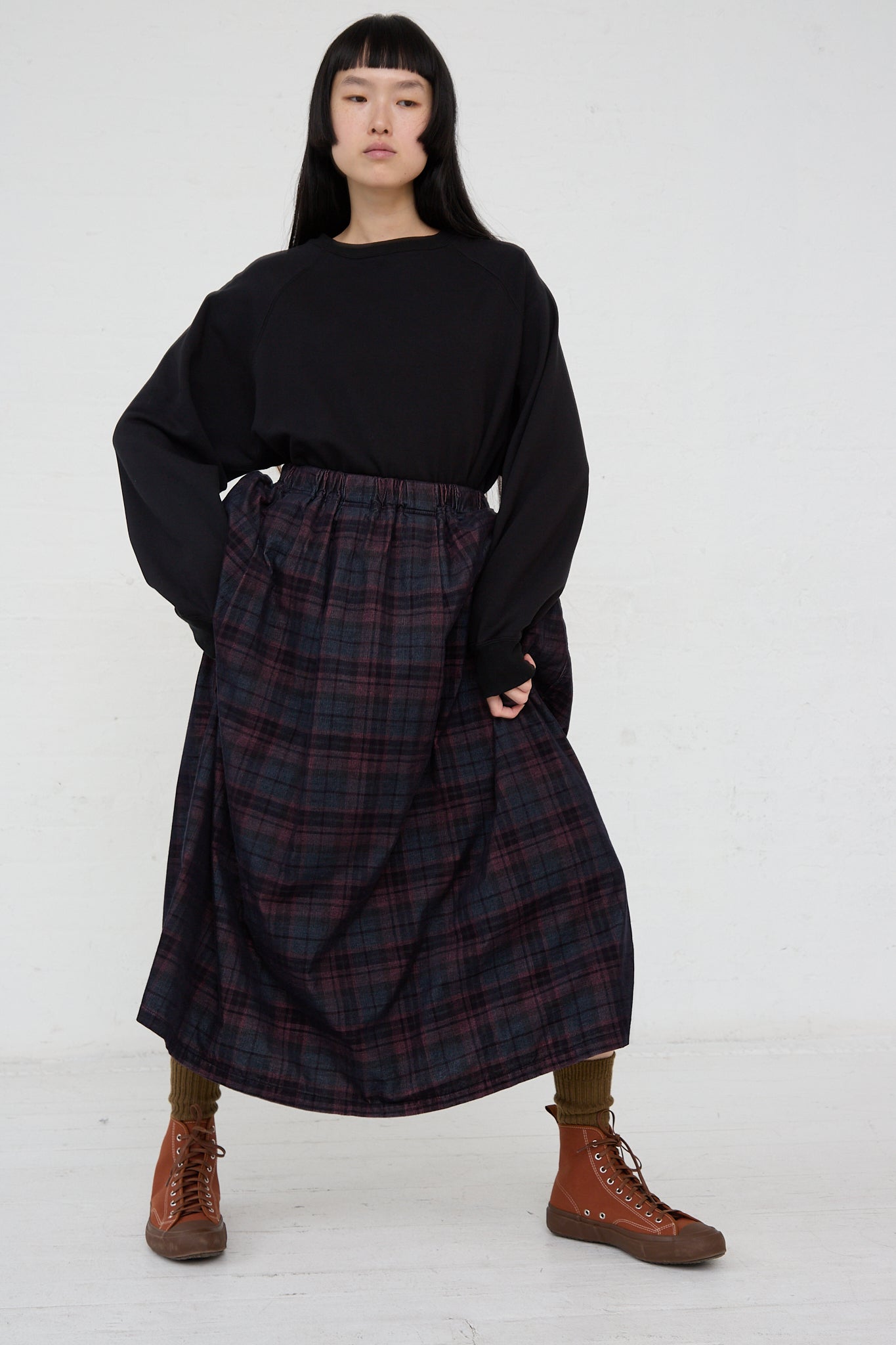 A woman wearing a black sweater and an Ichi Woven Cotton Skirt in Navy with an elasticated waist.