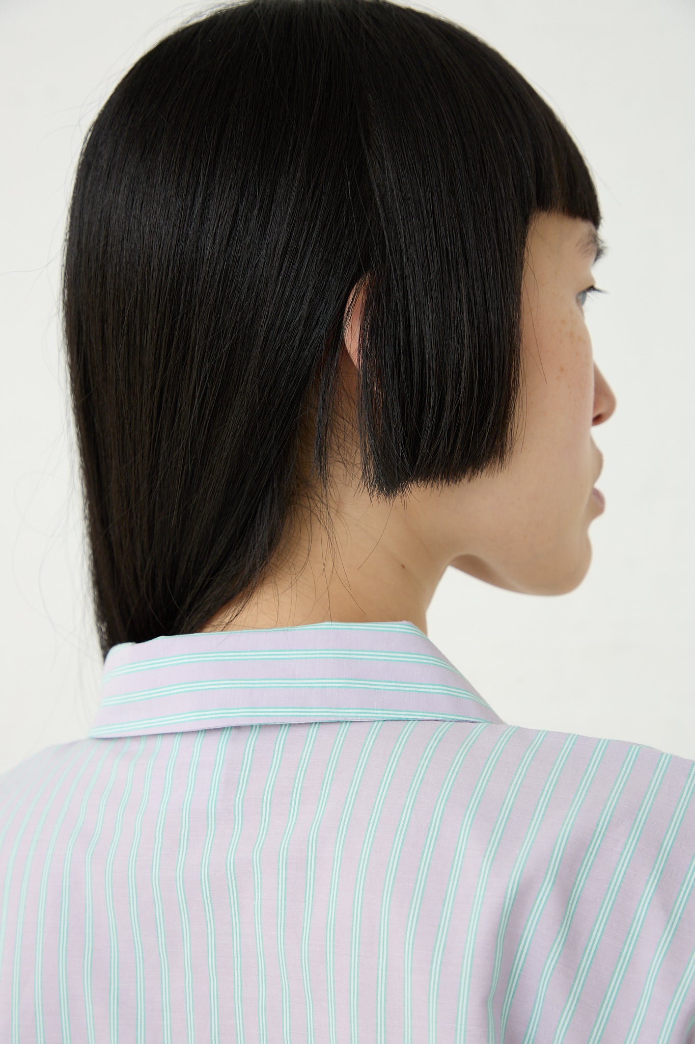 The back view of a woman wearing a Giza Cotton Kolla Shirt in Lilac Stripe made by Baserange. Up close view of collar.