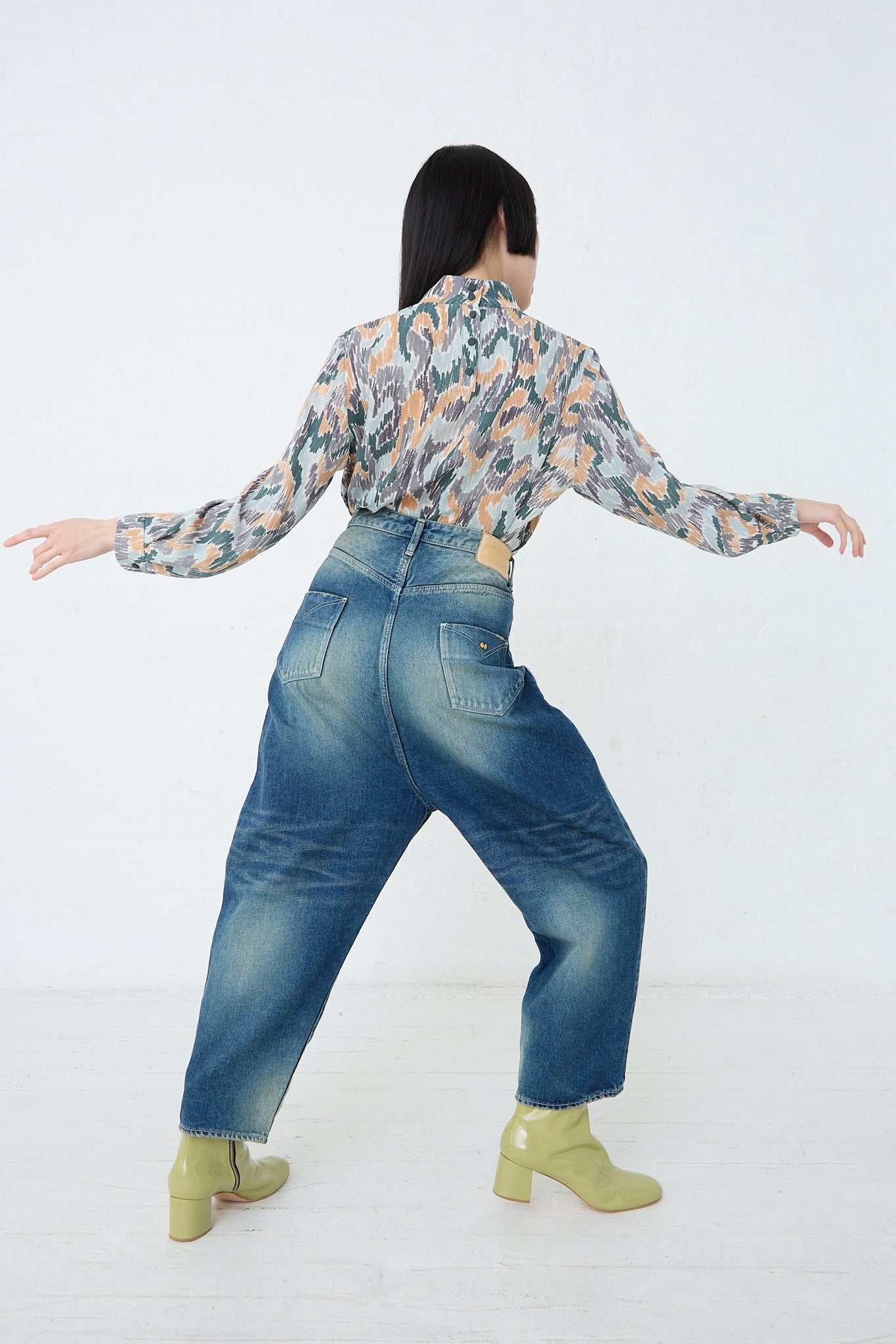 A woman wearing Mina Perhonen's Always New Tapered Pant in Blue and blouse. Back view and full length.