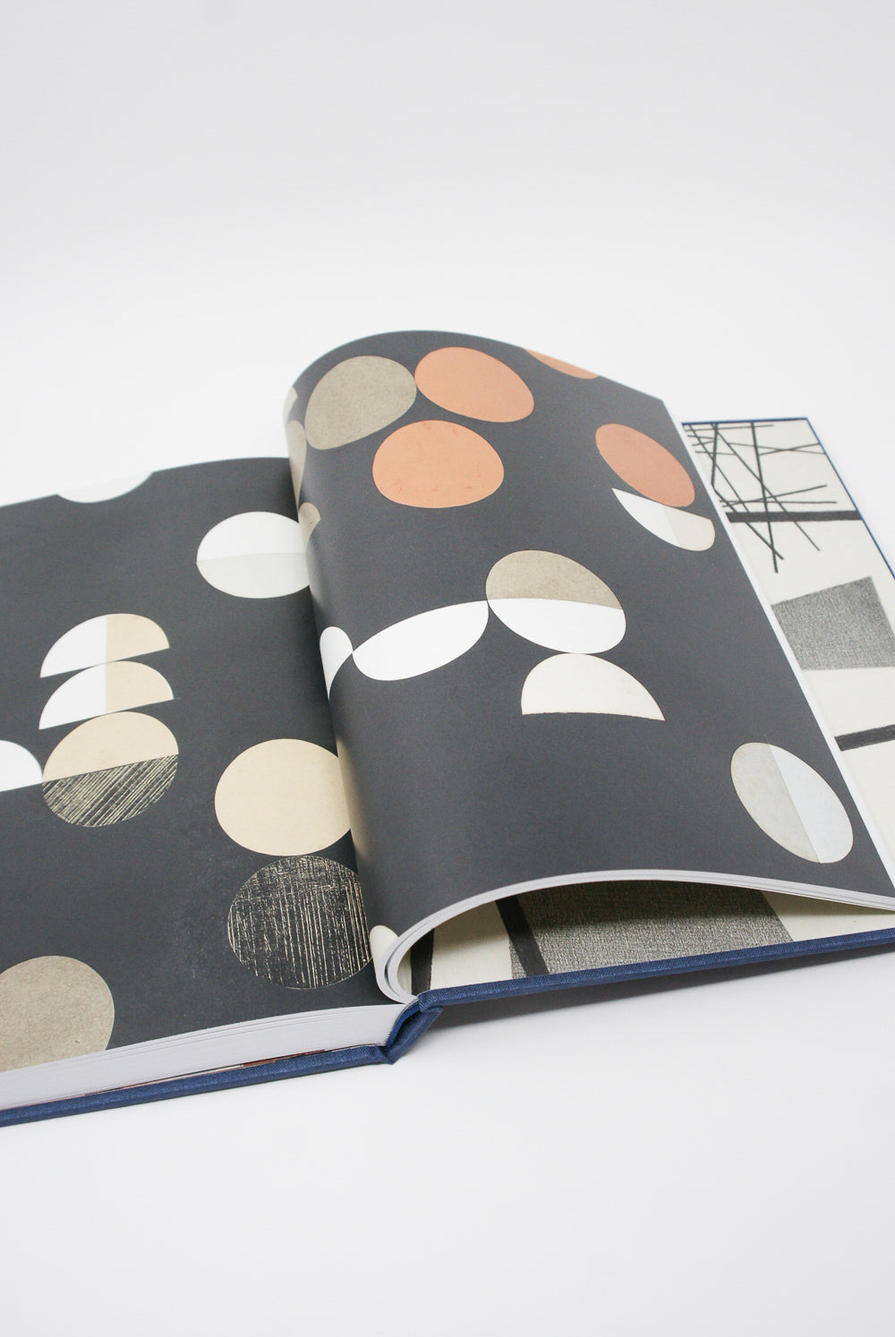 An open Sophie Taeuber-Arp: Living Abstraction book with black and white circles on it, displayed at the retrospective of abstract artist Taeuber-Arp by Artbook/D.A.P.