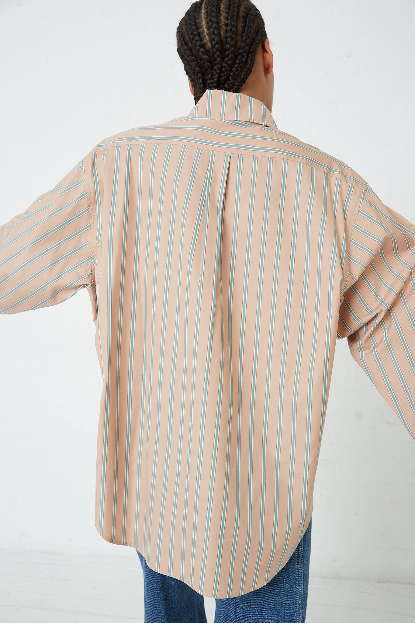 The back view of a woman wearing a Rachel Comey Stripe Broadcloth Risa Top in Terracotta.