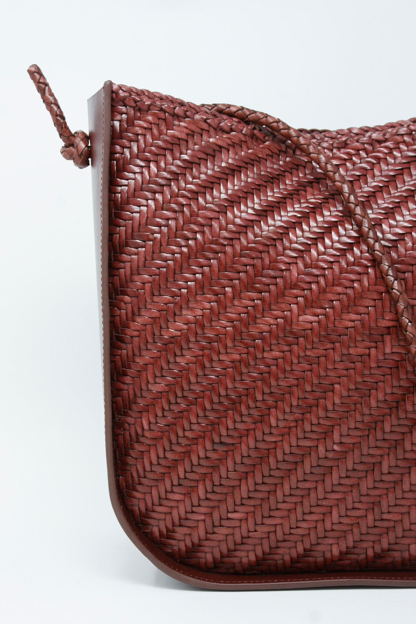 A Dragon Diffusion Wanaka Crossbody Bag in Bordo with a shoulder strap.