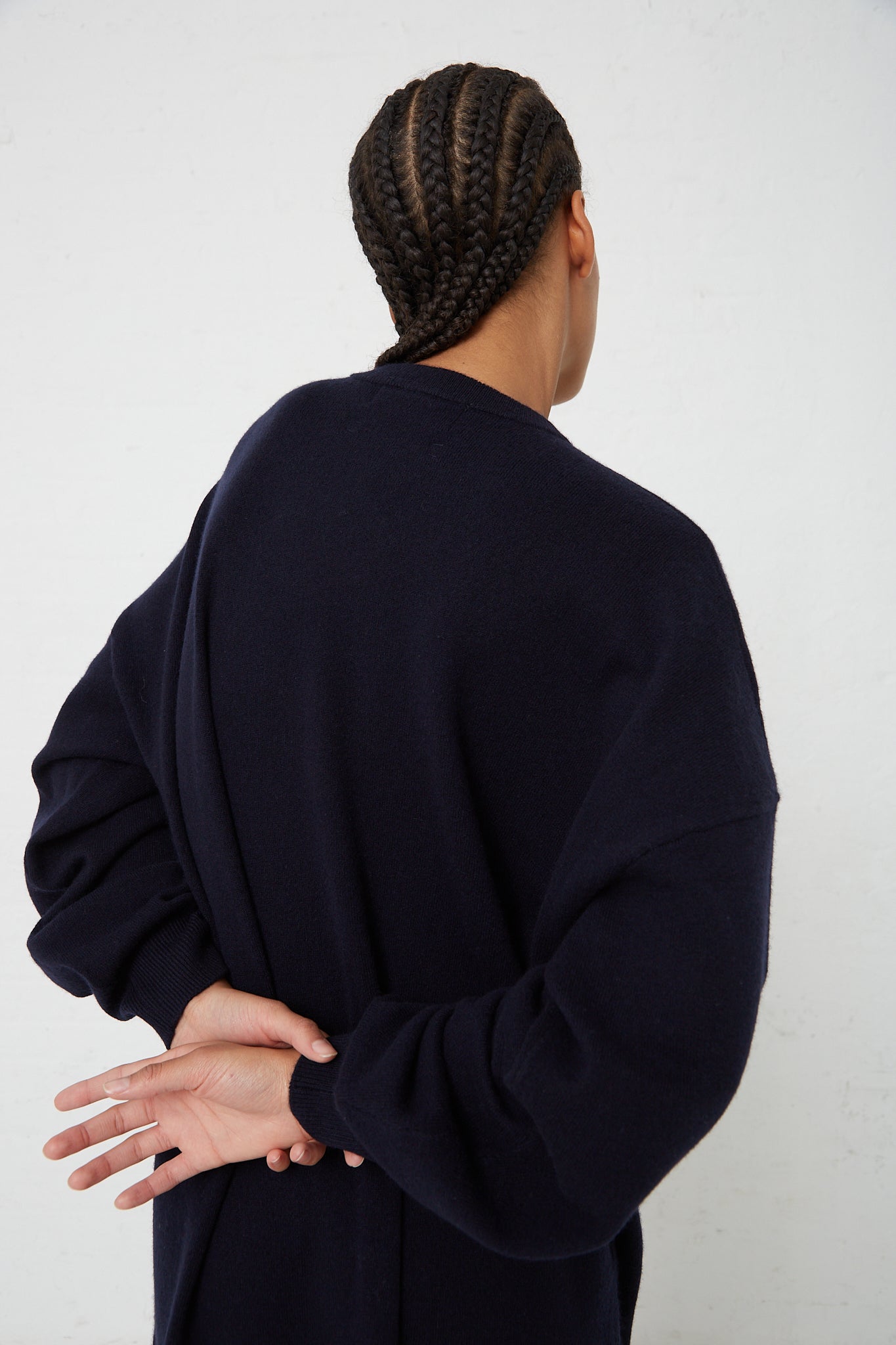 The back view of a woman wearing an Extreme Cashmere No. 106 Weird Dress in Navy.