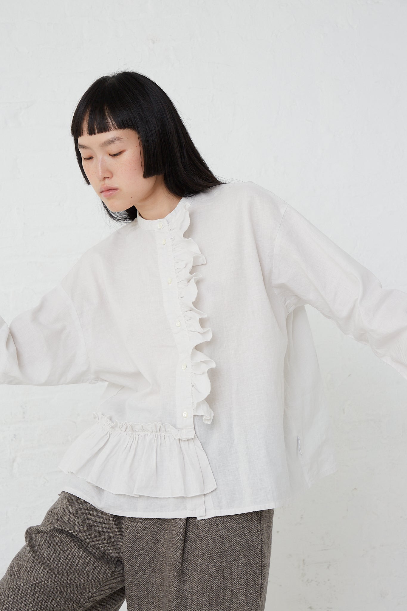 A woman wearing a UpcycleLino Linen Gathered Frill Blouse in Off White made by nest Robe.