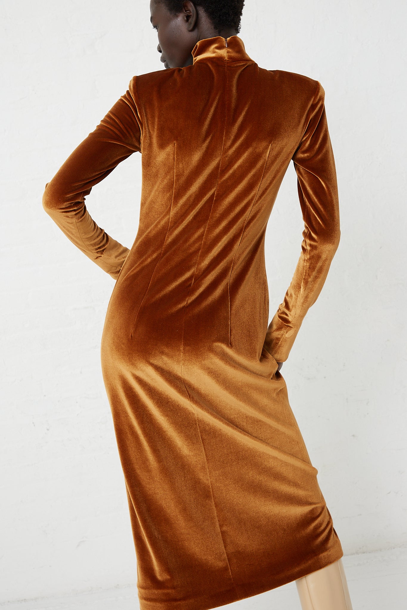 The back view of a woman in a slim fit Velvet Turtleneck Dress in Cognac made by Veronique Leroy.