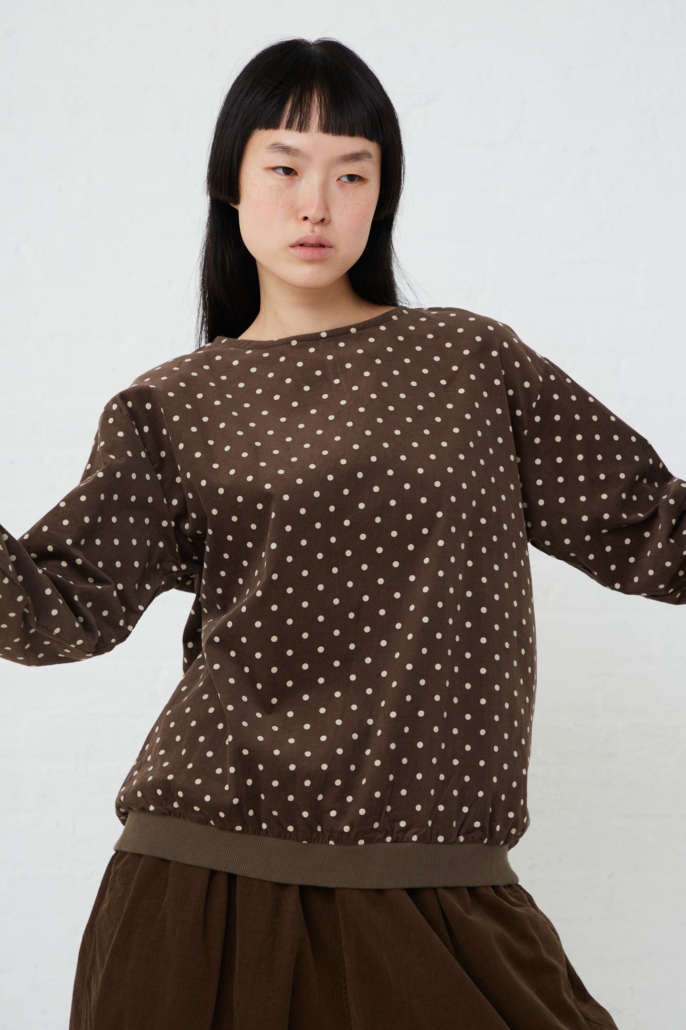 The model is wearing an Ichi Cotton Polka Dot Pullover in Brown.