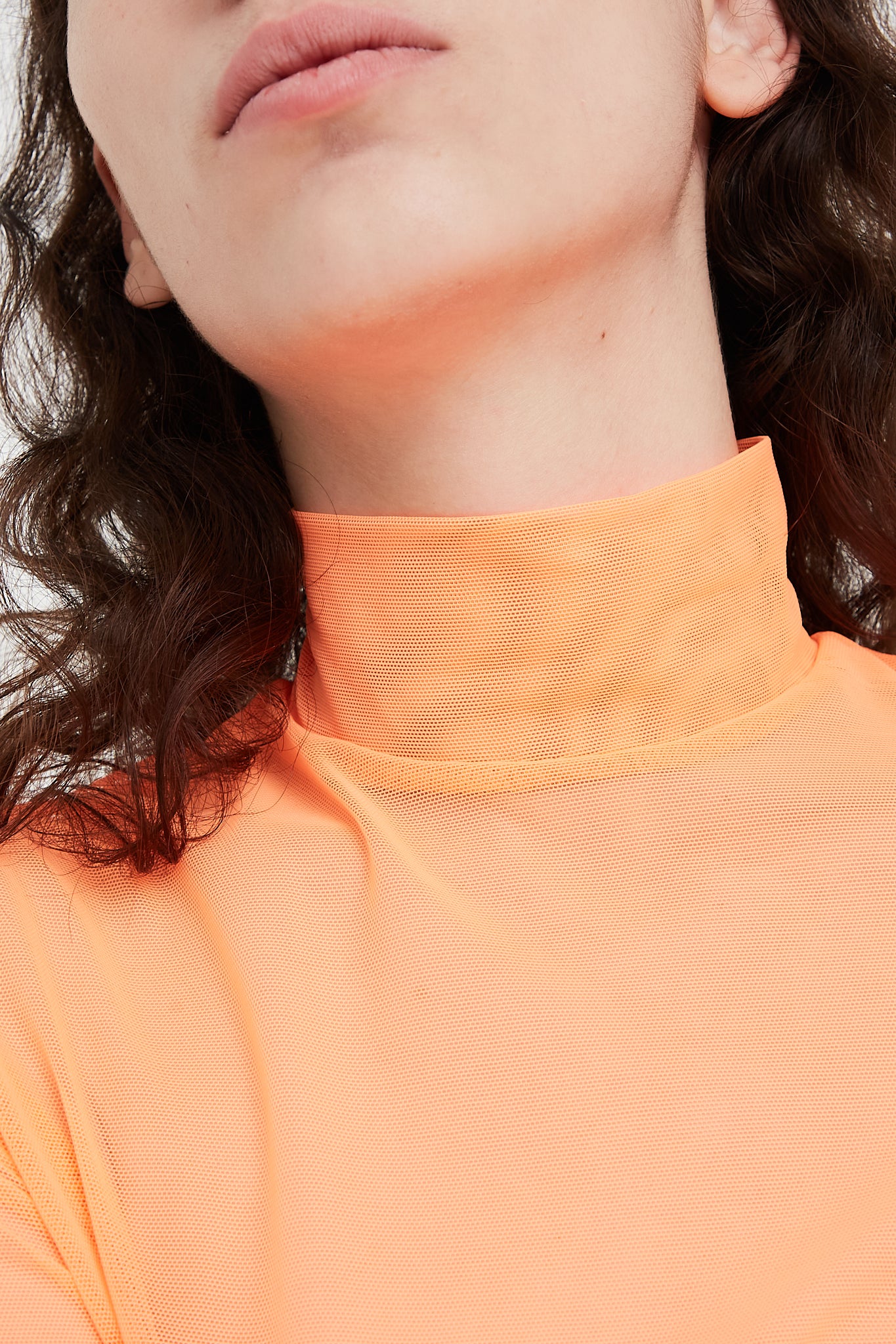 A Long Sleeve Mesh Mockneck in Fluoro Orange, designed by Nomia brand at Oroboro Store