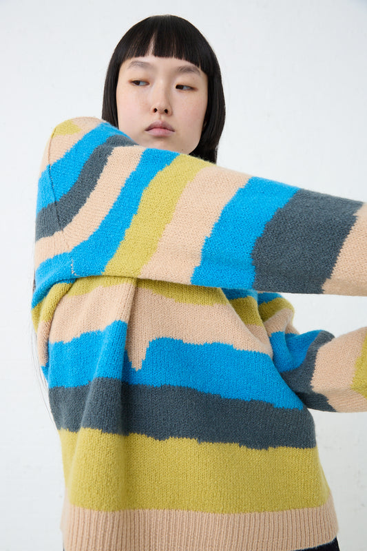 A woman wearing a Light Wind Sweater in Blue Mix by Mina Perhonen with a stripe design. Front view. 