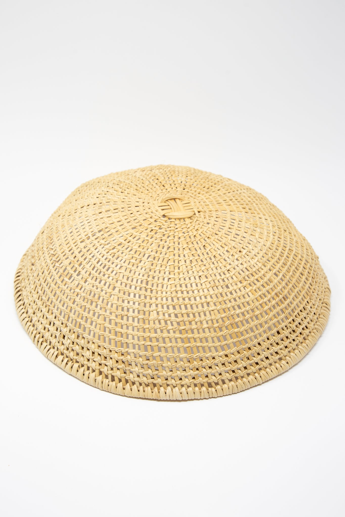 An artisan-crafted round woven Medium Avia Pova Basket, showcasing exquisite weaving techniques, set against a pristine white background by Plaza Bolivar.