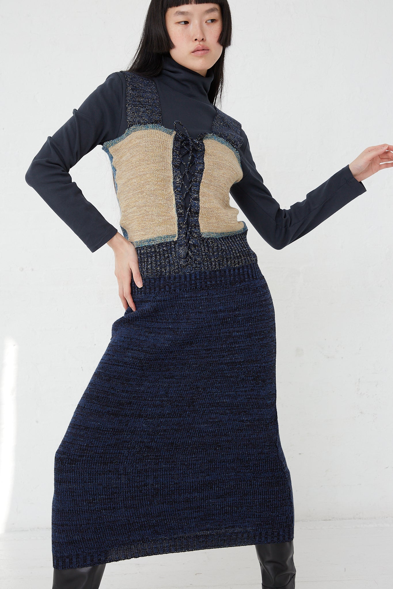 A woman in the Optic Dress in Blue C by Intensity and black boots.