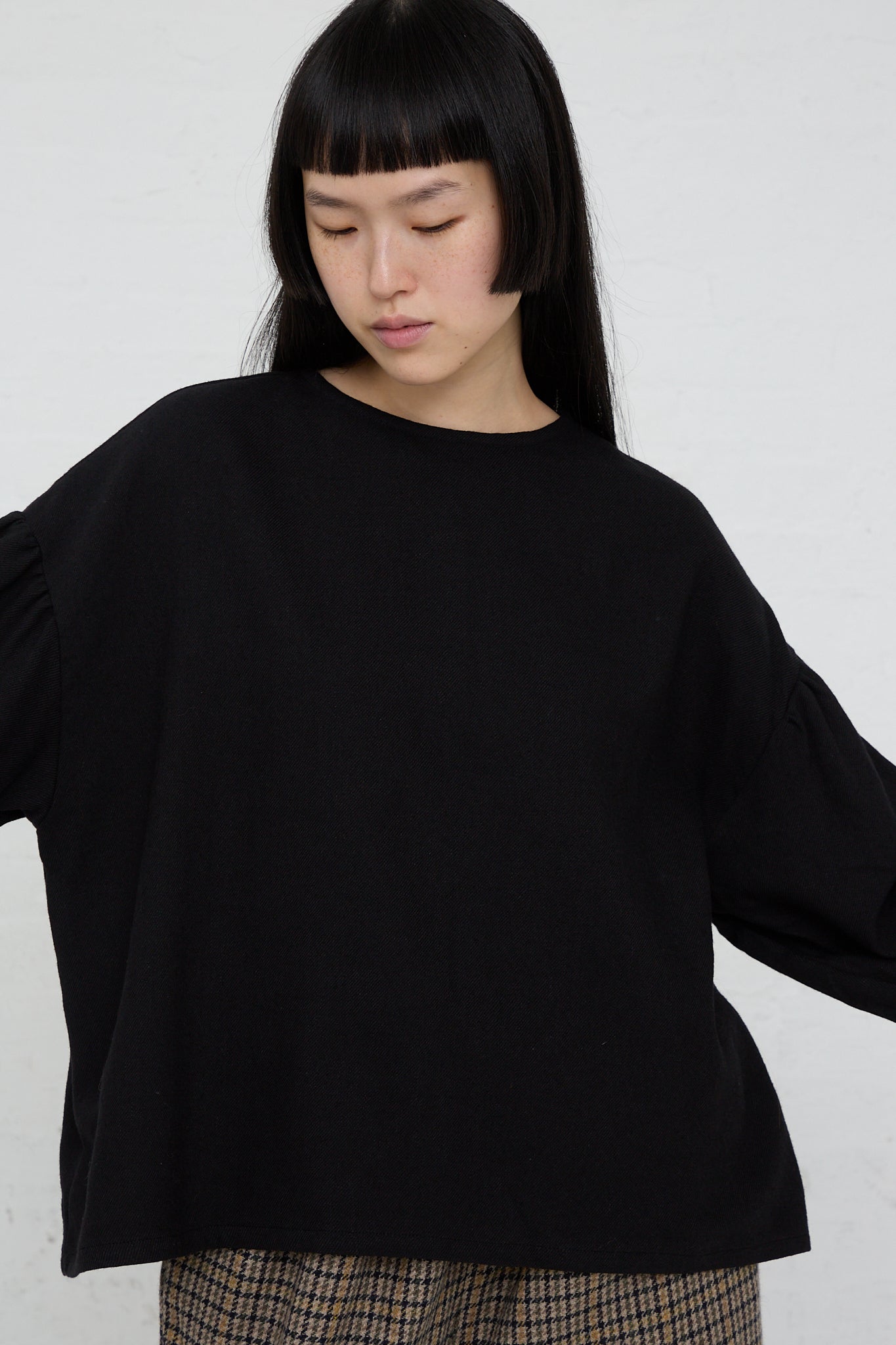 The model is wearing a relaxed fit Two-Way Blouse in Black with puff sleeves by Ichi.