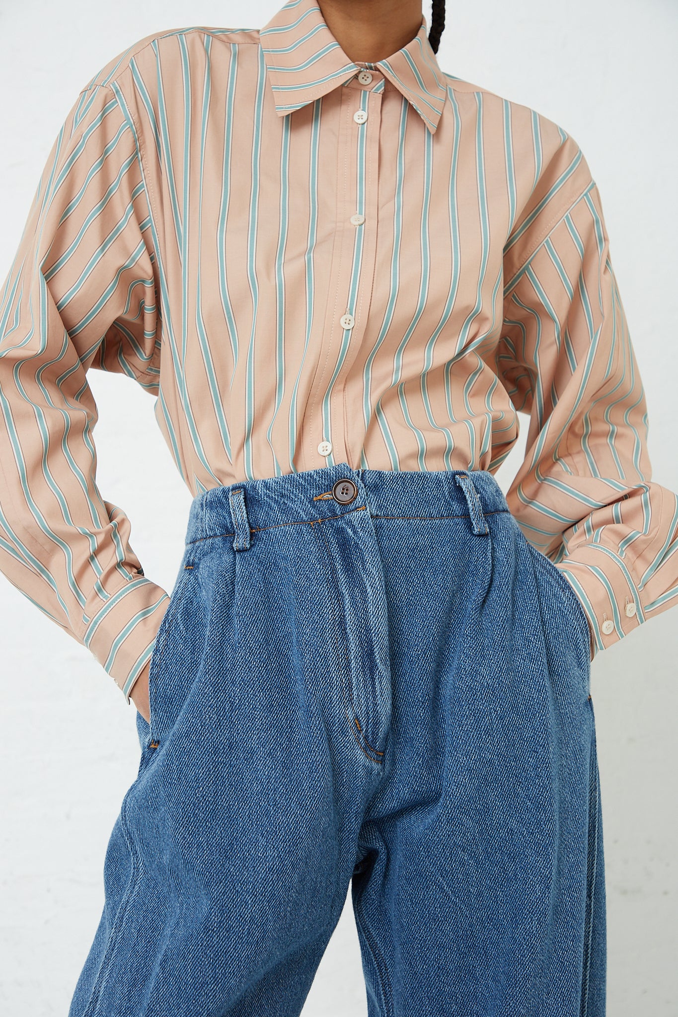 A woman wearing a striped shirt and Rachel Comey's Denim Percy Pant in Indigo.