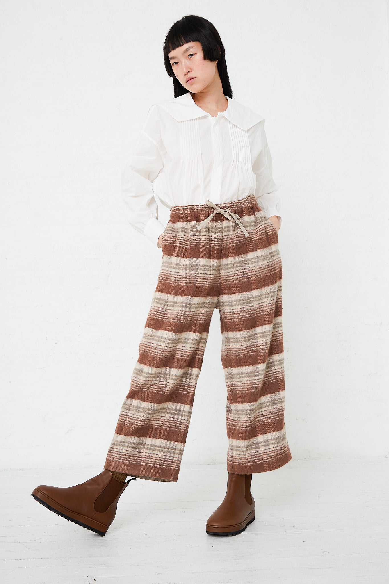 A woman wearing a white shirt and Silk Plaid Mosser Cloth Pajama Pants in Cocoa Brown by Toujours.