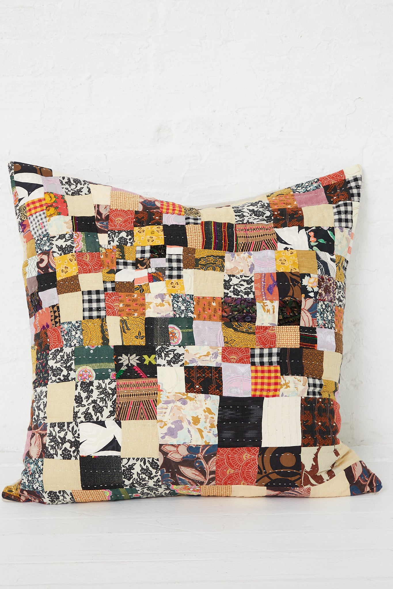 A Counterpane Patchwork Pillows in Brown Multi II, with antique found cloth and showcasing a freehand quilting style, placed on a white background.