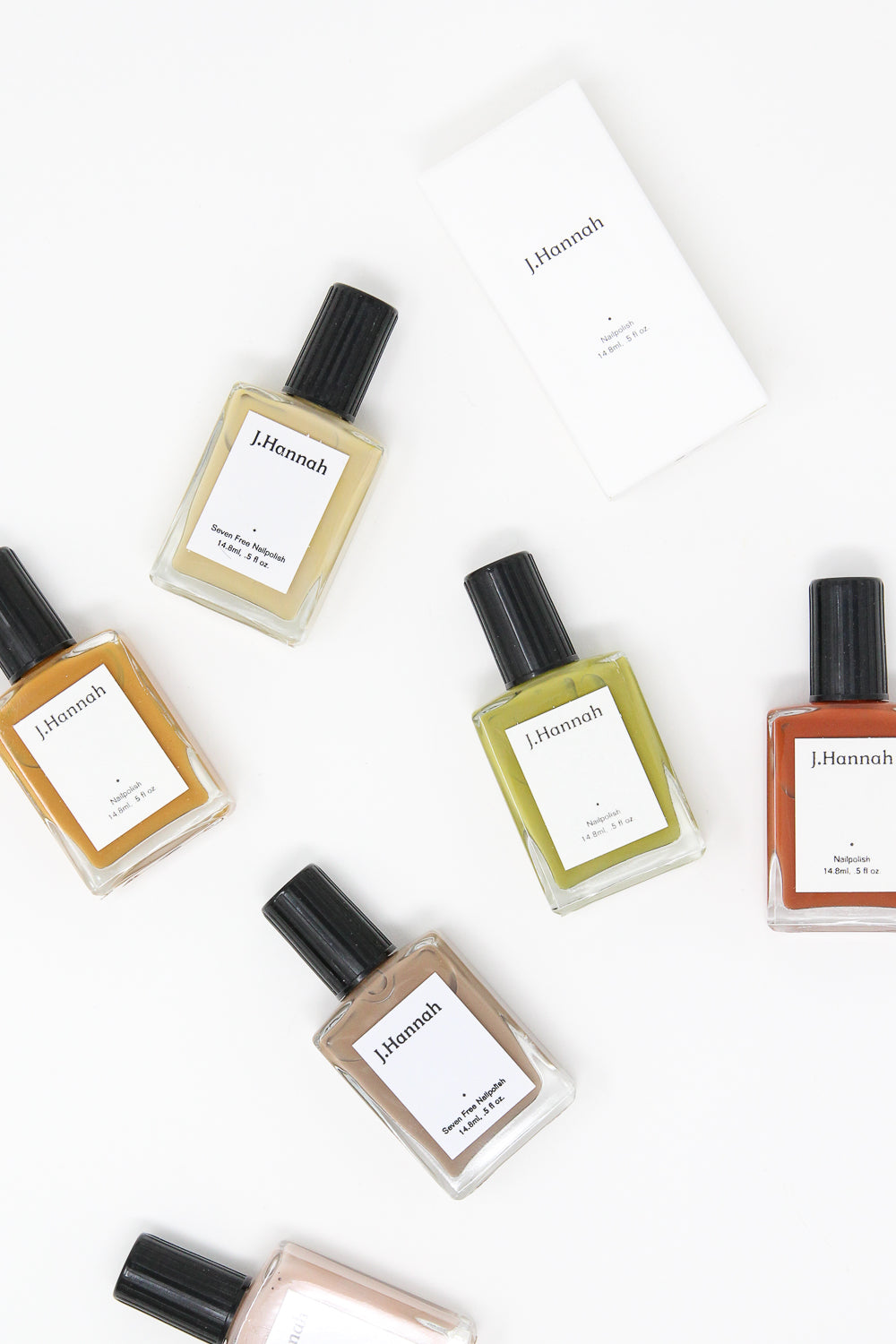Five J Hannah Eames nail polishes in vibrant colors on a white surface.