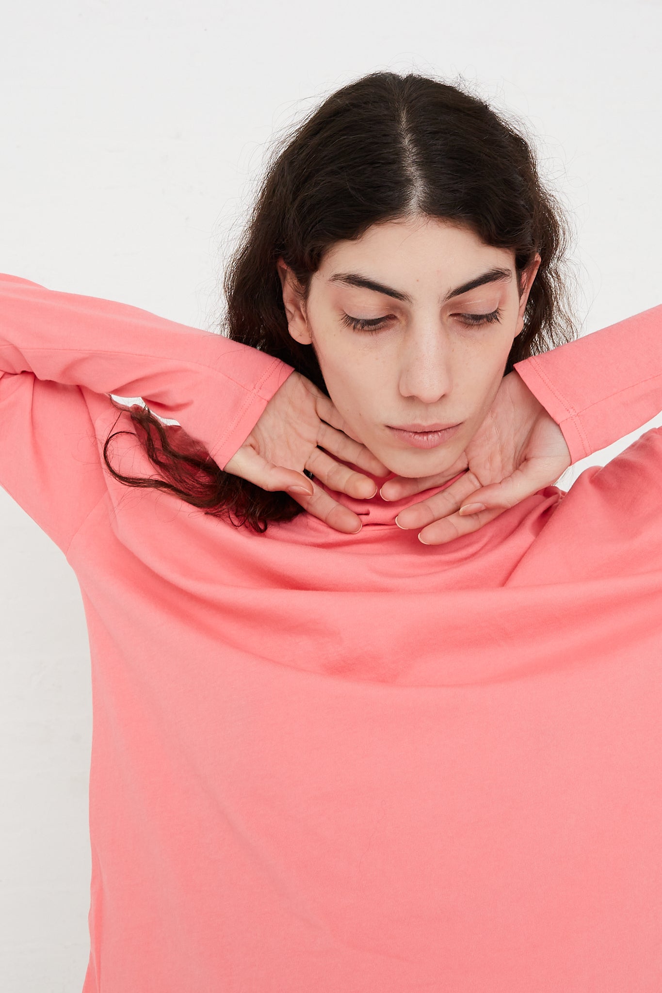 A model wearing a Cotton Turtleneck Shirt in Calla Pink by B Sides.